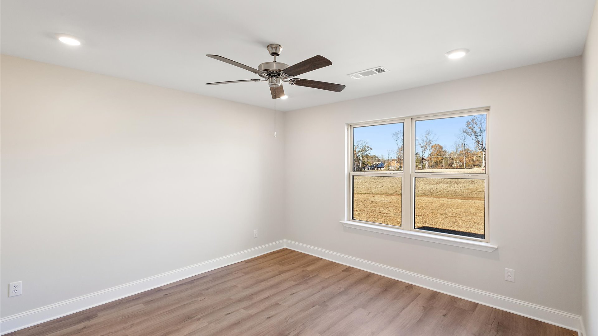 primary bedroom with hardwood floors, recessed lighting, ceiling fan, and window