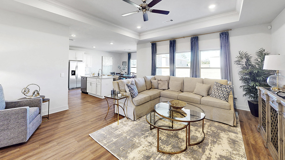 open floor plan living space with hardwood floors, tray ceilings, and ceiling fan