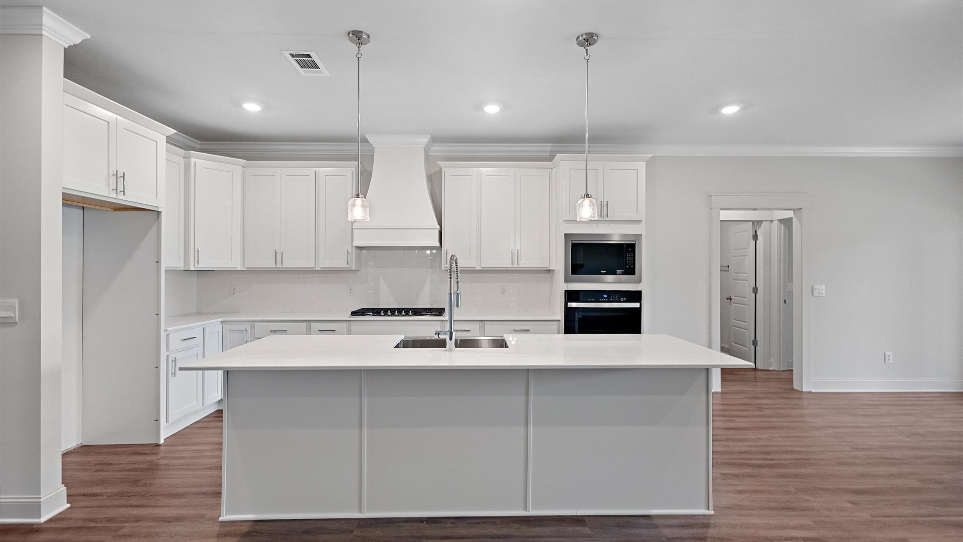 beautiful spacious kitchen featuring white cabinetry, large island and stainless steel appliances