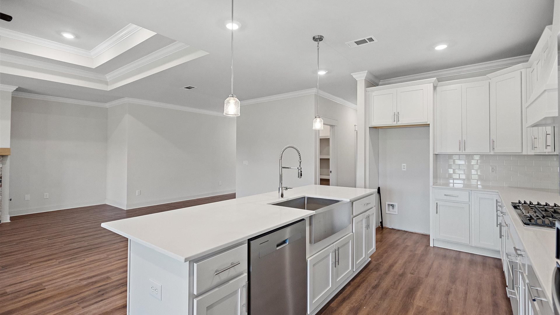 beautiful spacious kitchen featuring white cabinetry, large island and stainless steel appliances