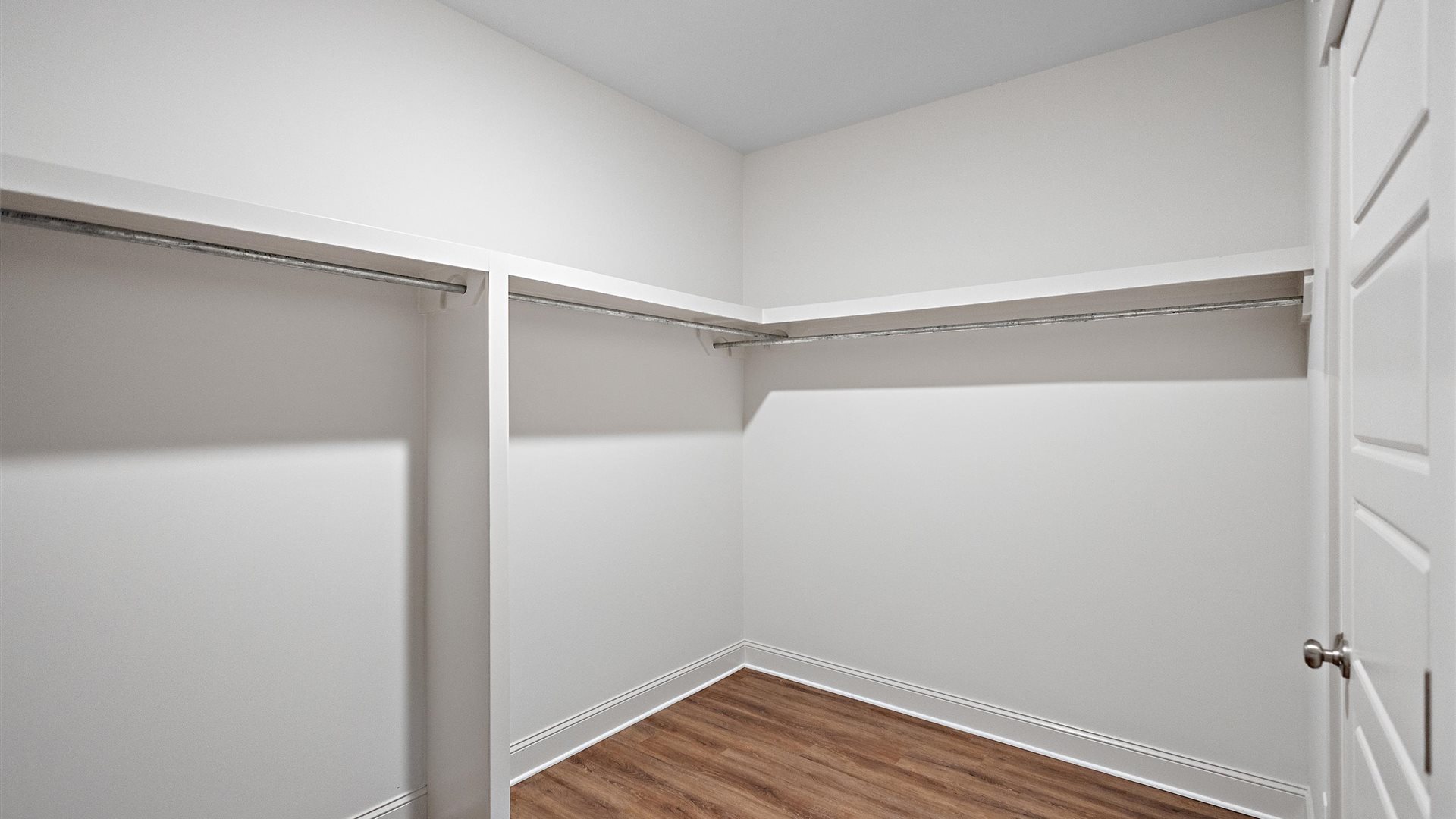 spacious primary closet featuring built in shelves