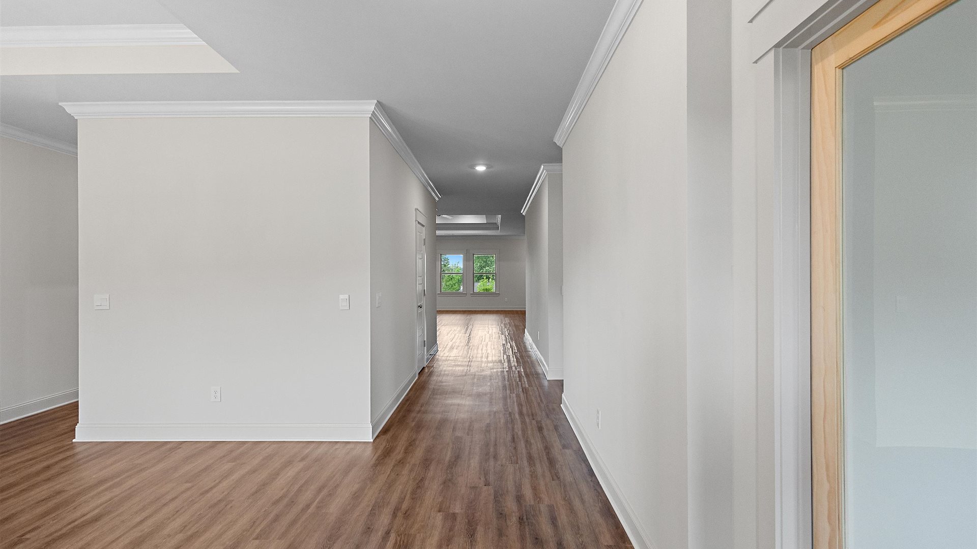 entry way hallway featuring brown floors and white walls