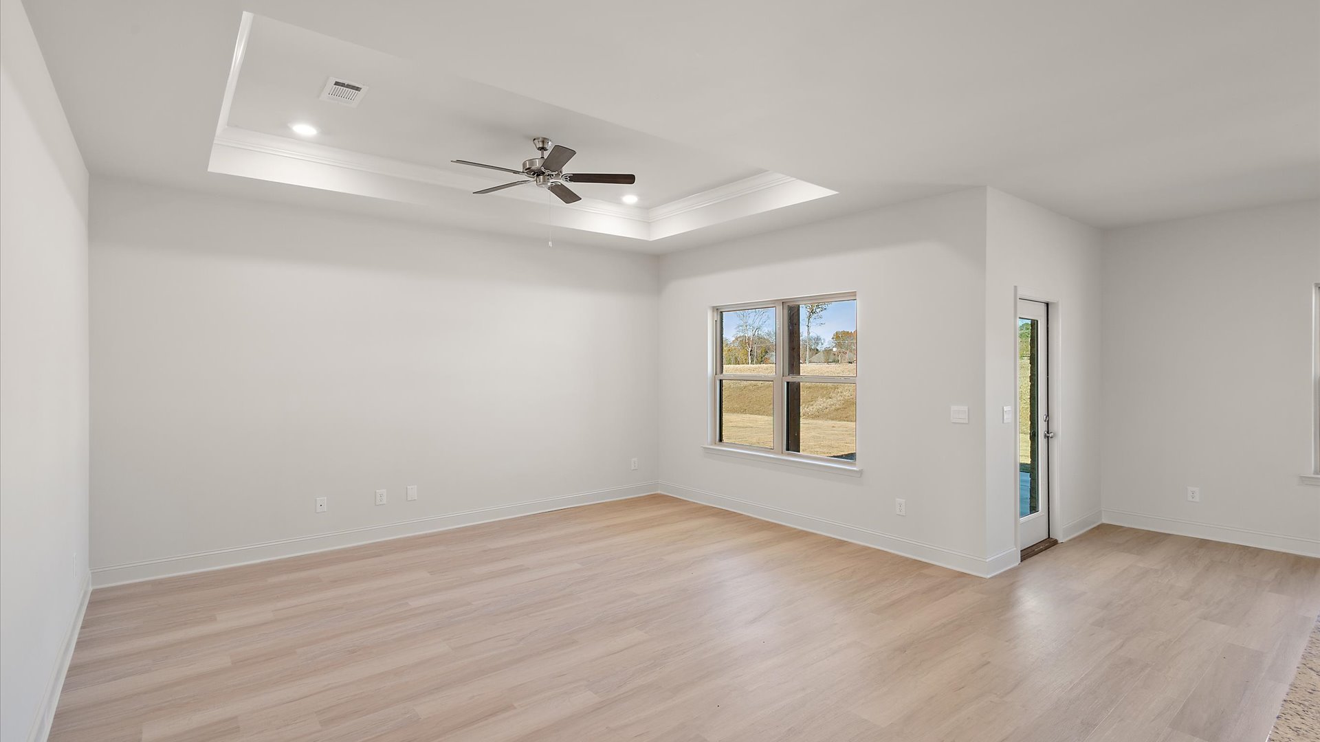 living space with hardwood floors, tray ceilings, recessed lighting, and ceiling fan