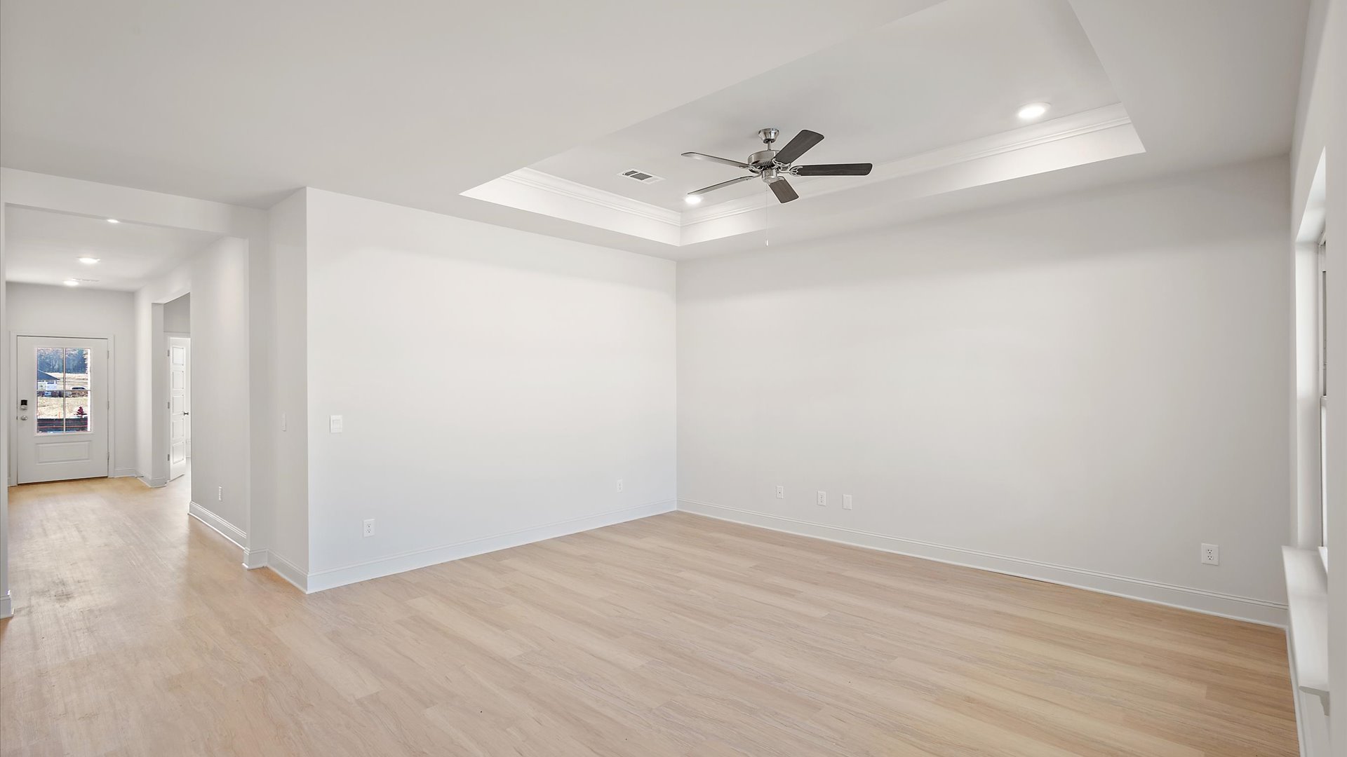living space with hardwood floors, tray ceilings, recessed lighting, and ceiling fan