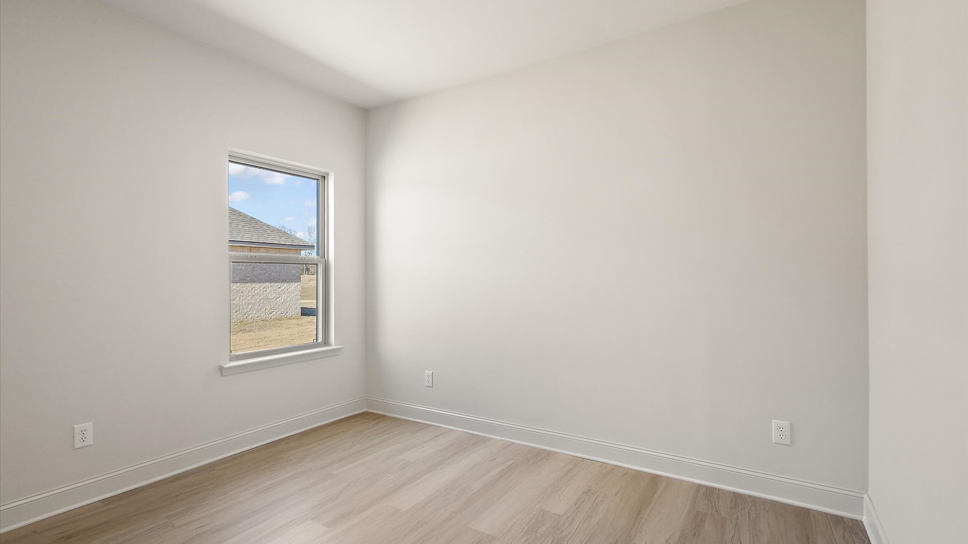 additional bedroom with hardwood floors and window