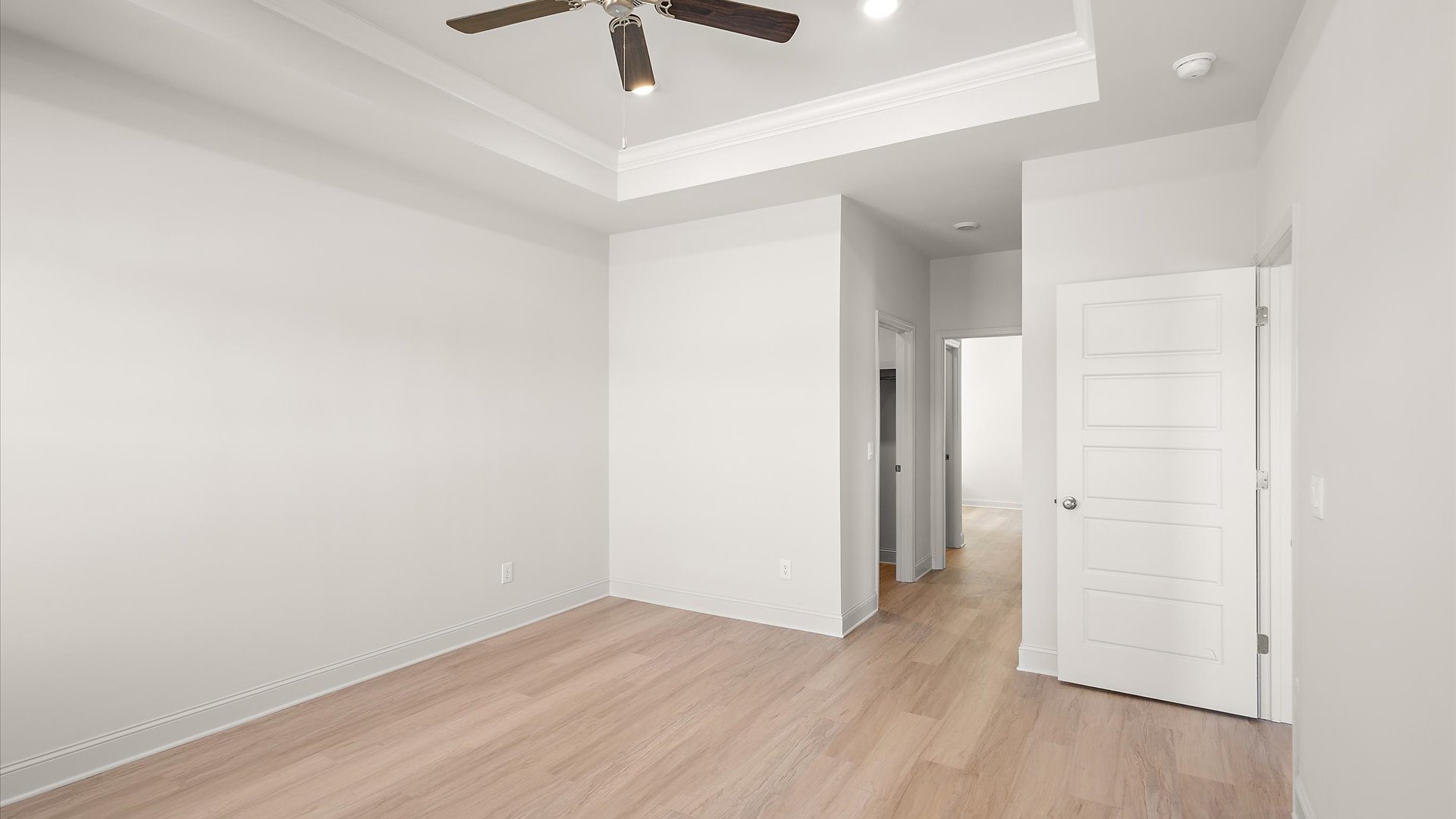 primary bedroom with hardwood floors, tray ceilings, recessed lighting, and ceiling fan