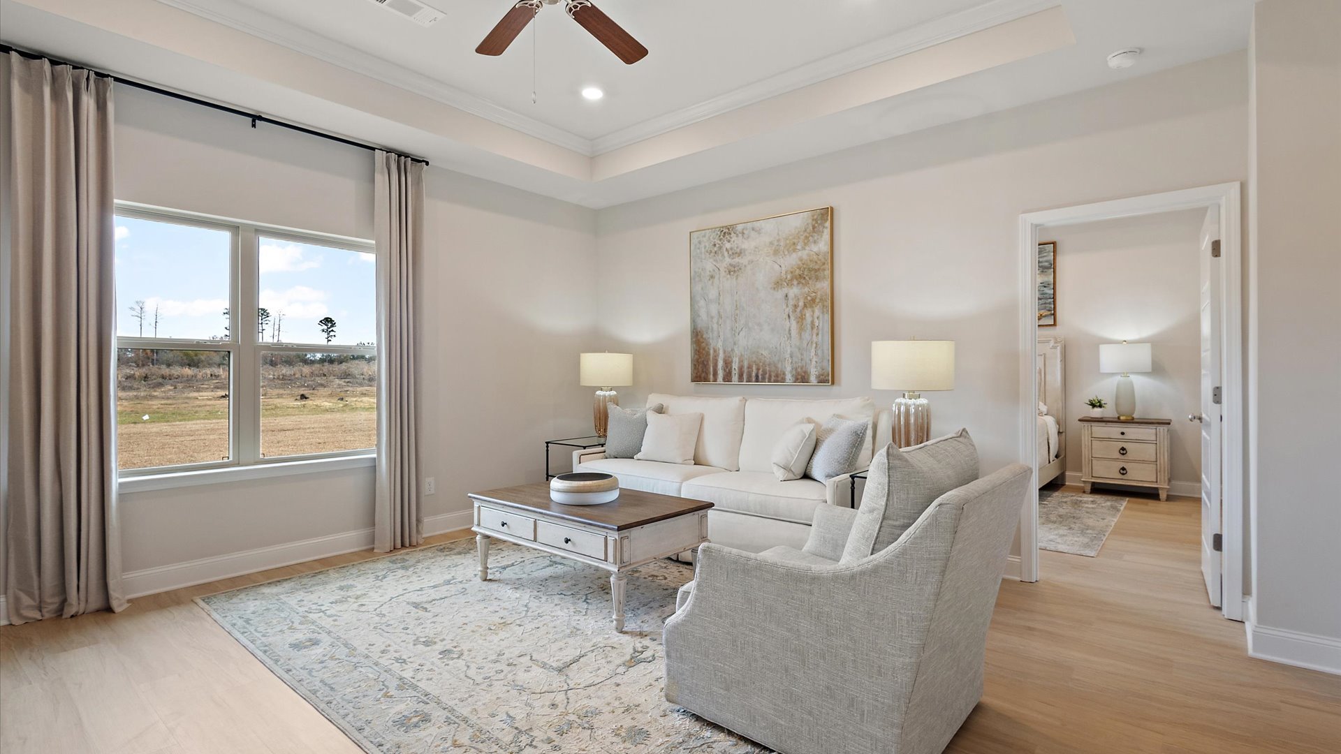 living space with hardwood floors, ceiling fan, tray ceilings, and recessed lighting