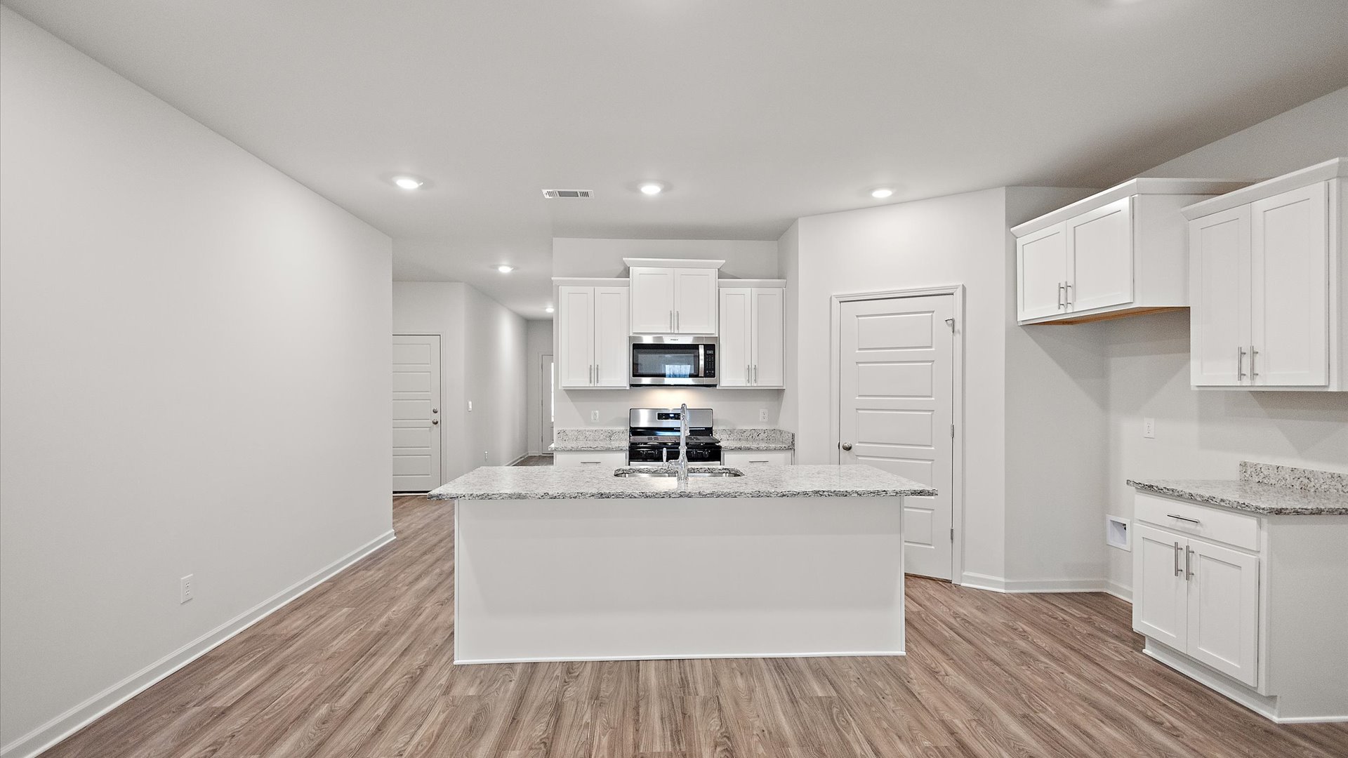 Spacious kitchen with granite countertops, island, and stainless-steel appliances.