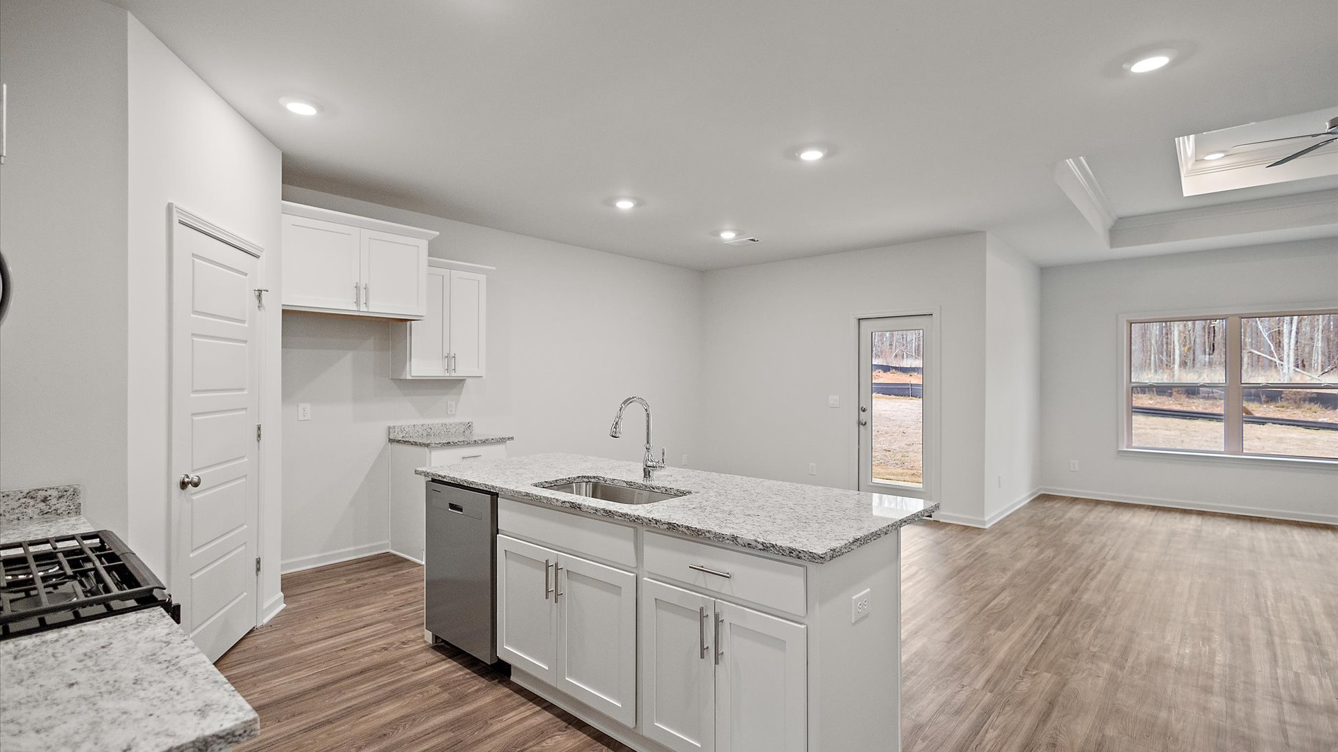 Spacious kitchen with granite countertops, island, and stainless-steel appliances.