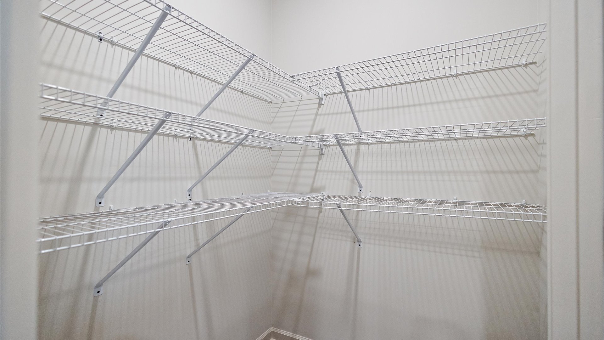 Pantry with wire shelving and recessed lighting.