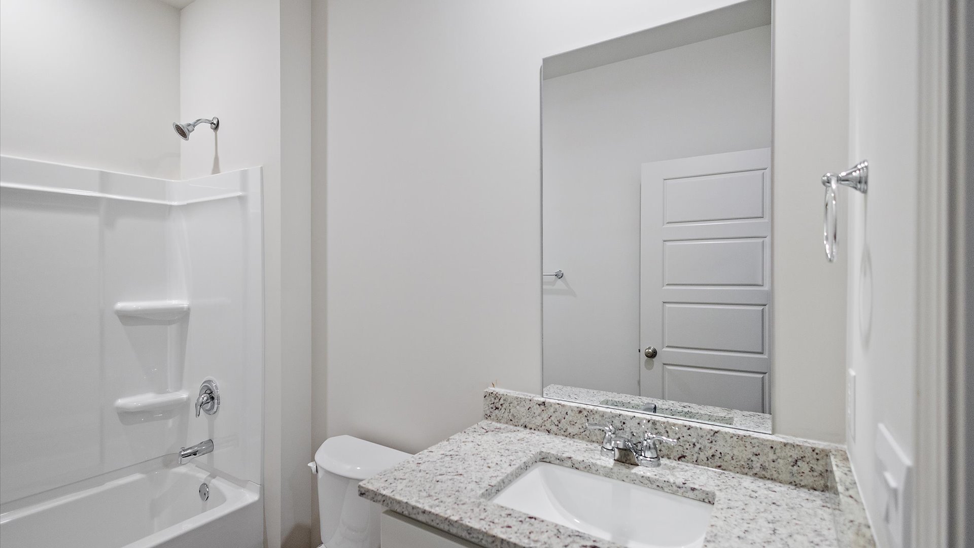 Single vanity bathroom with shower and tub combination.