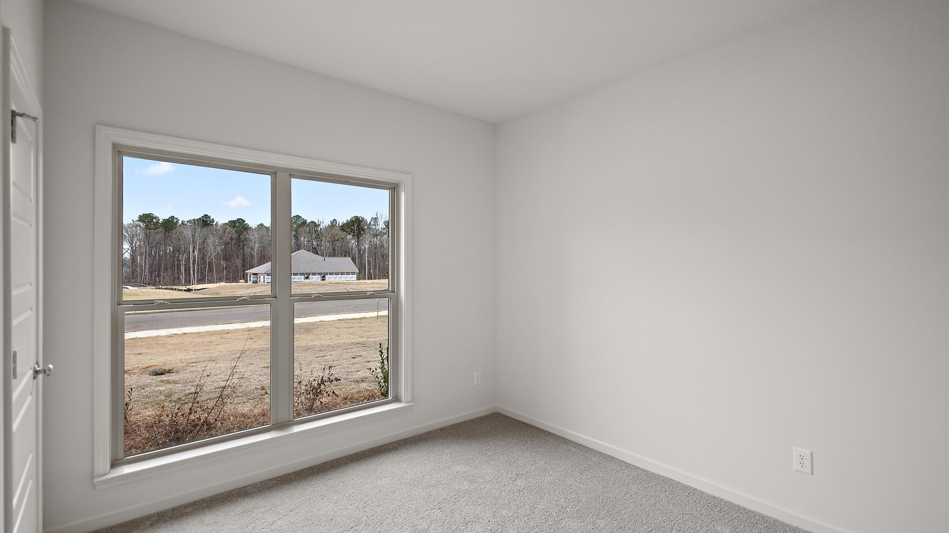 Additonal bedroom with carpeted floors, recessed lighting, and a window for natural light.