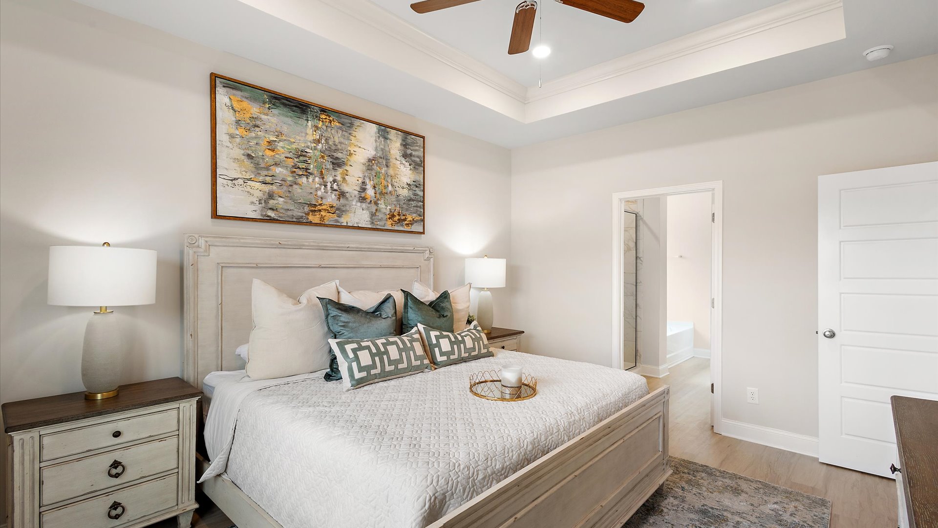 primary bedroom with window for natural light, hardwood floors, tray ceilings, ceiling fan, and recessed lighting