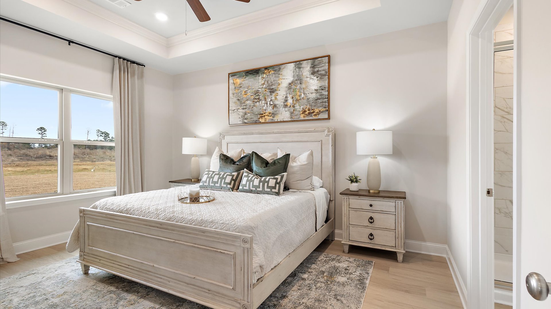 primary bedroom with window for natural light, hardwood floors, tray ceilings, ceiling fan, and recessed lighting