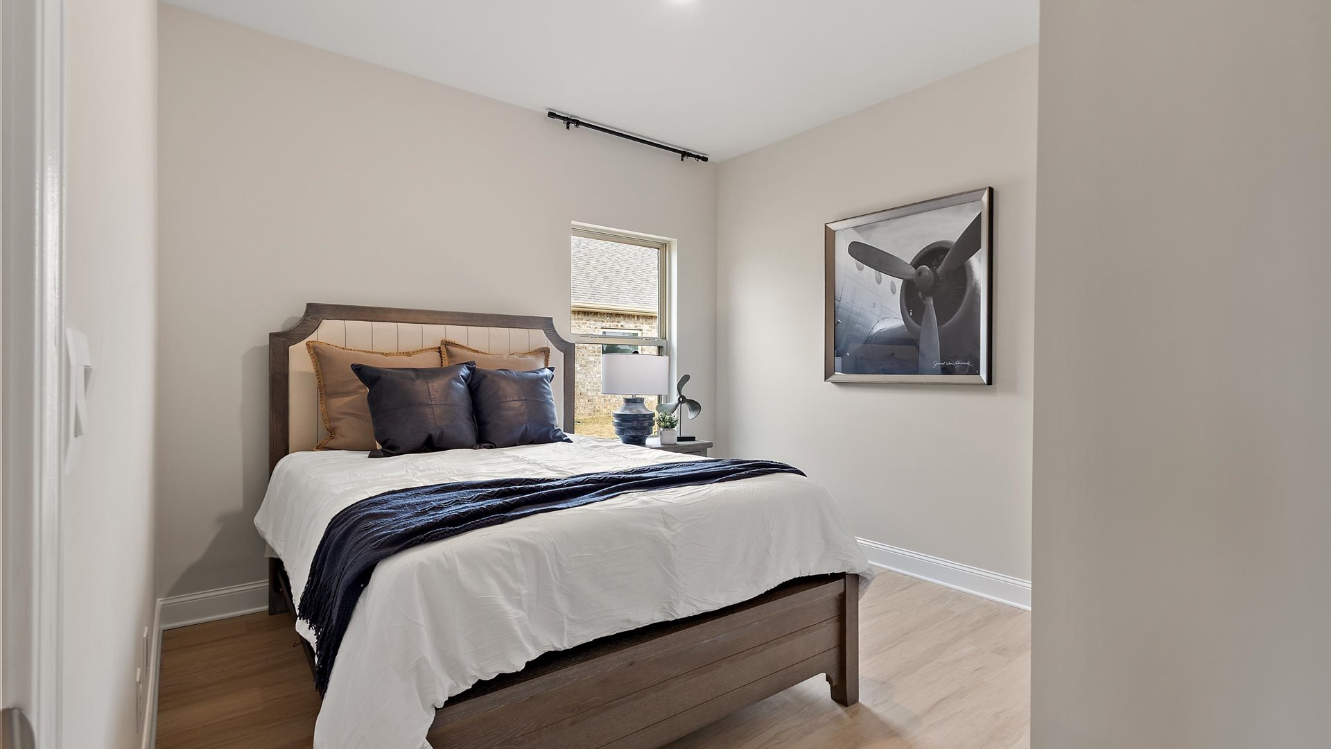 additional bedroom at front of home with hardwood floors and window for natural light