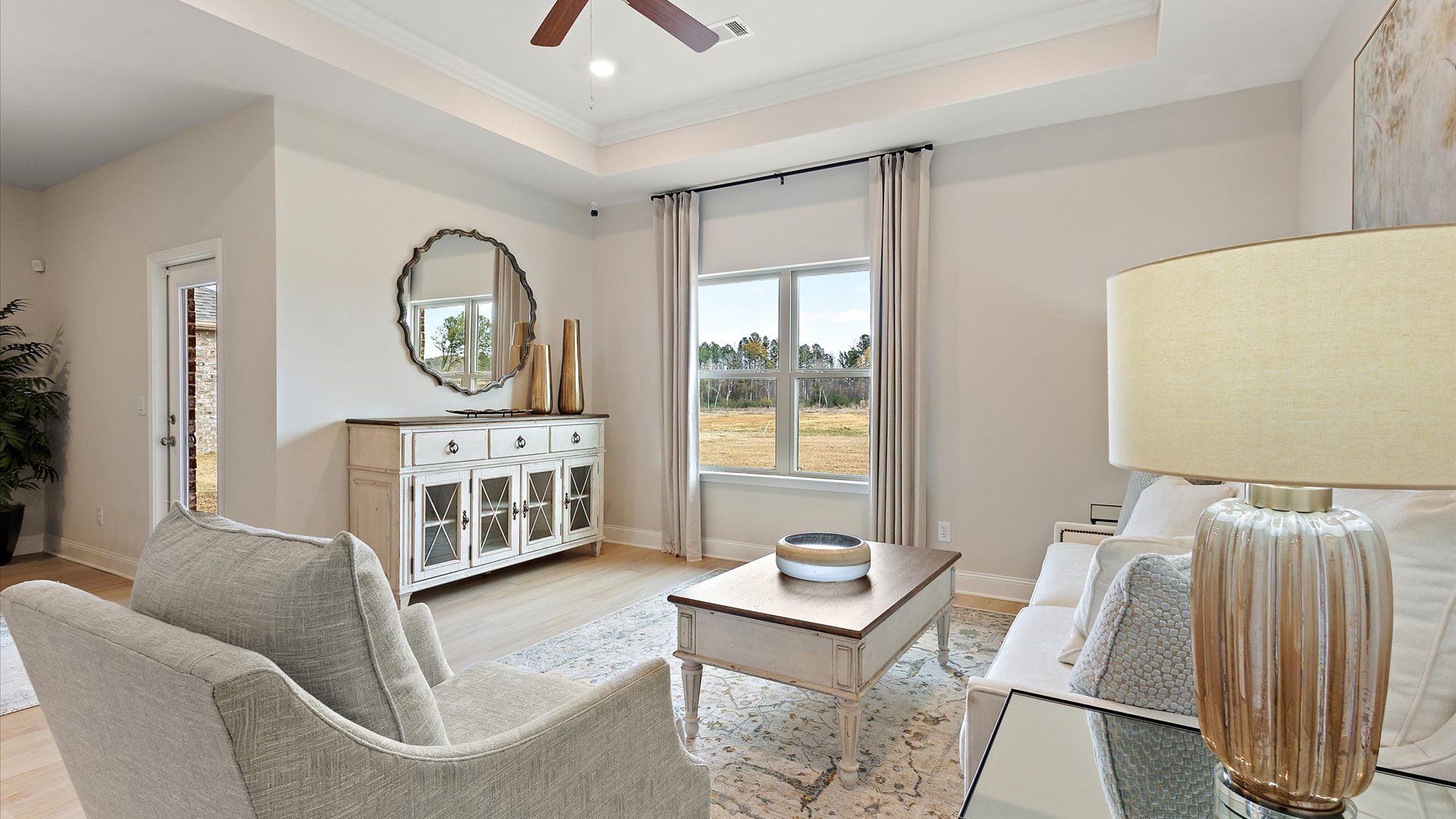 living space with hardwood floors, ceiling fan, tray ceilings, and recessed lighting