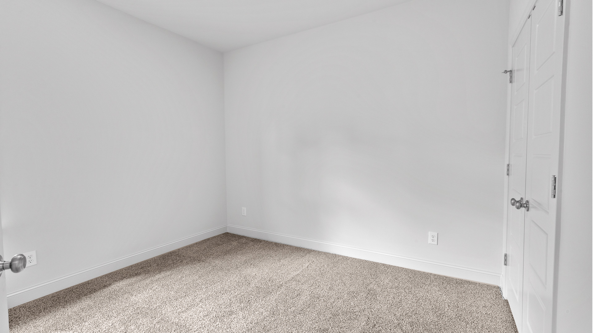 Carpeted bedroom two with a single window and a closet.