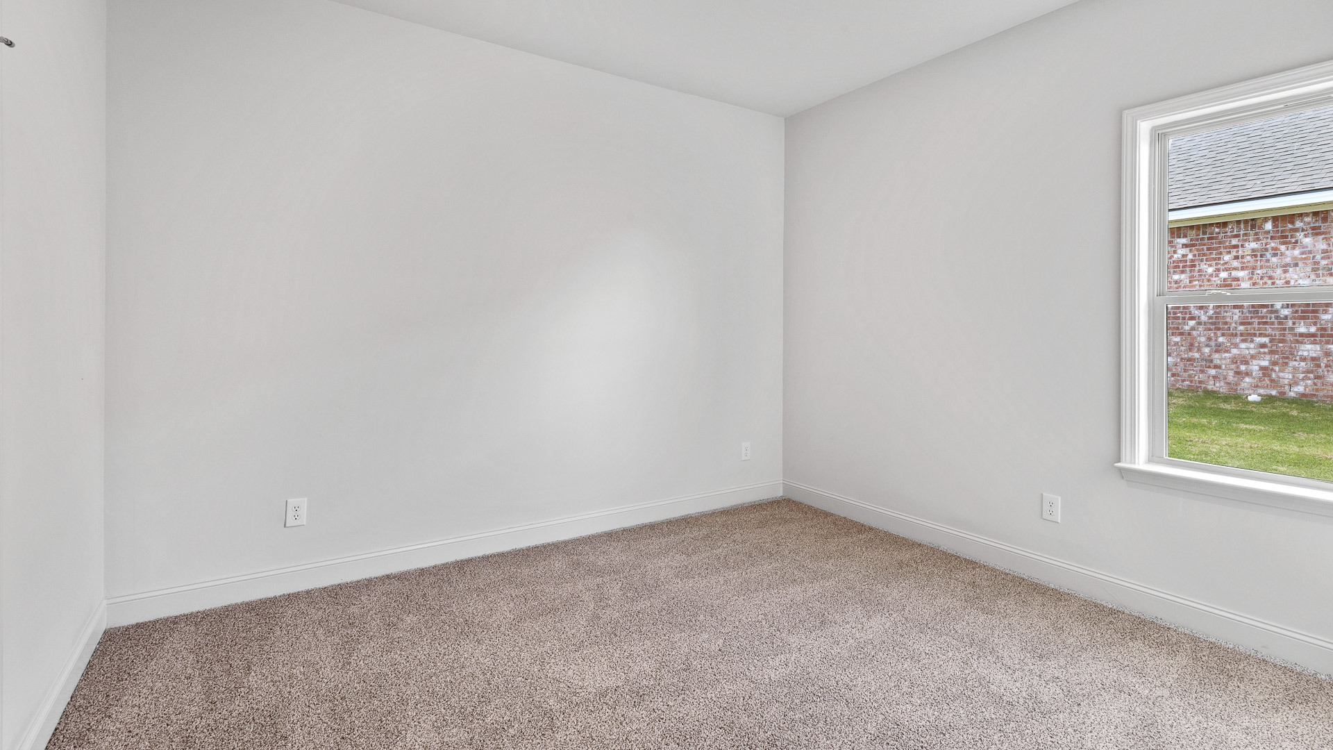 Carpeted bedroom two with a single window.