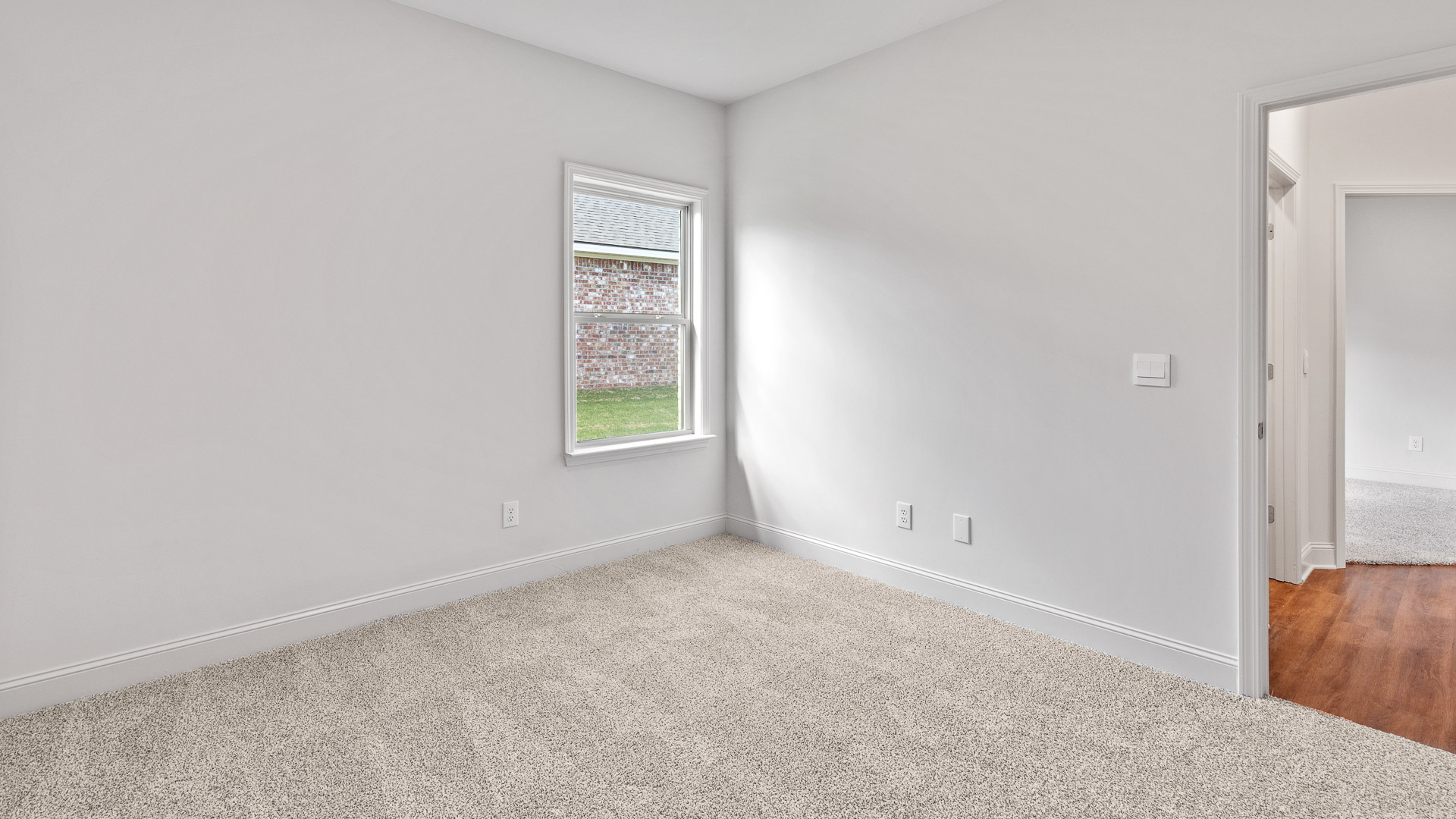 Carpeted bedroom two with a single window.