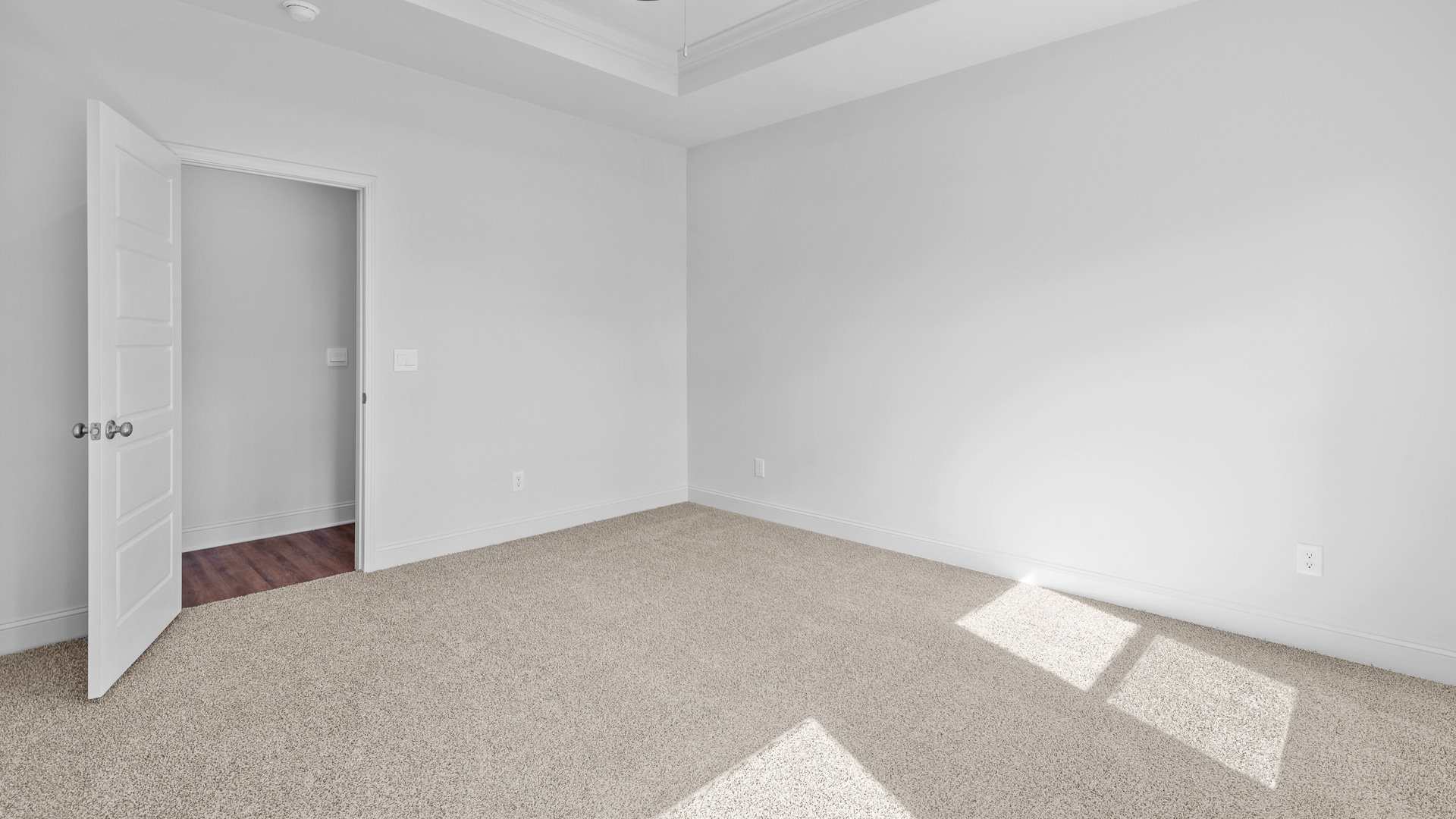 Carpeted bedroom 1 with a view of the entrance and hall.
