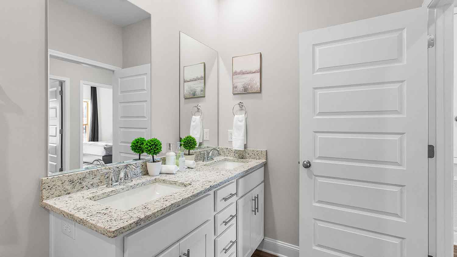 bathroom featuring dual sink vanities, a toilet and a shower