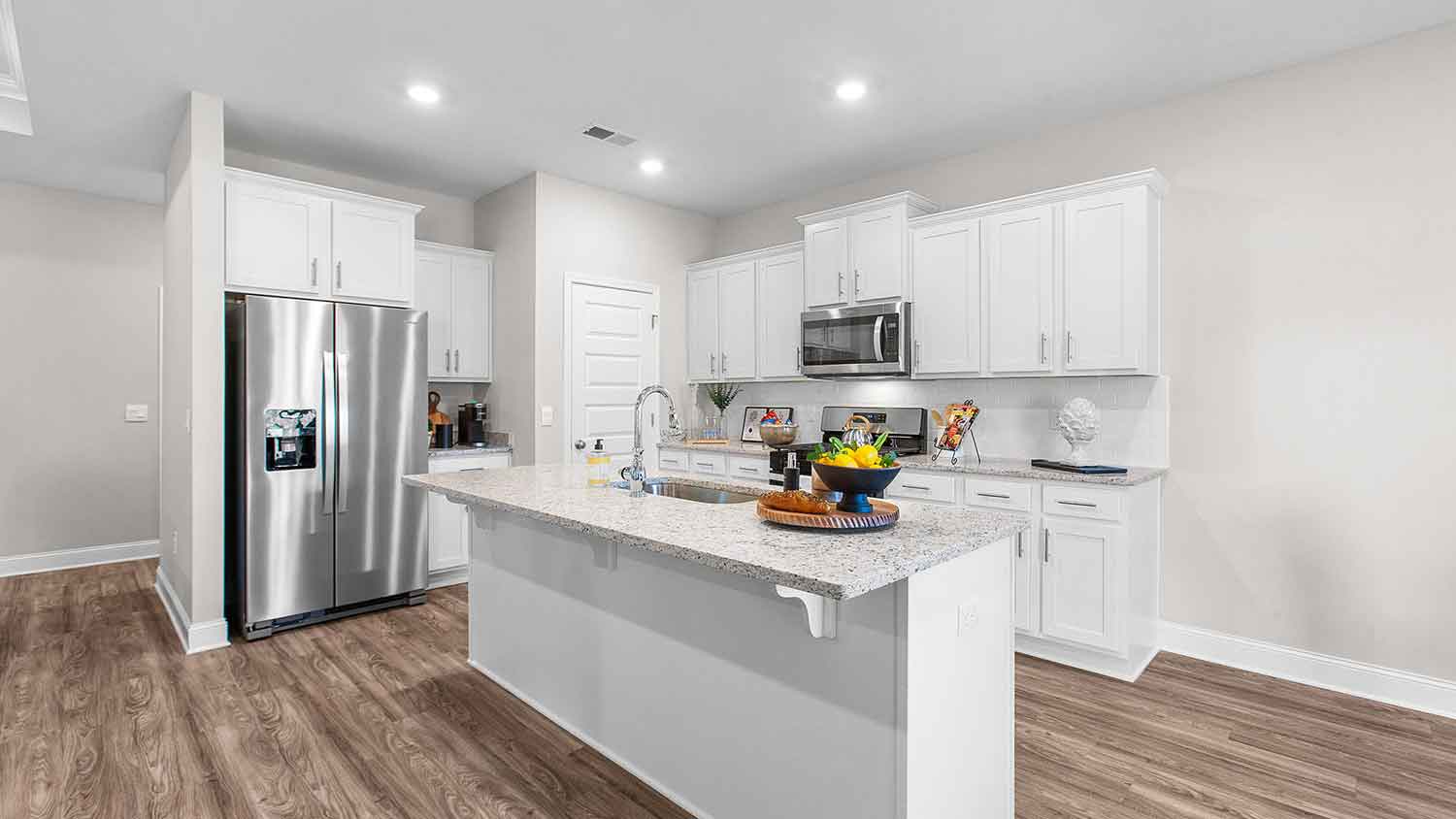 modern kitchen featuring a large island, white cabinetry, and stainless-steel appliances