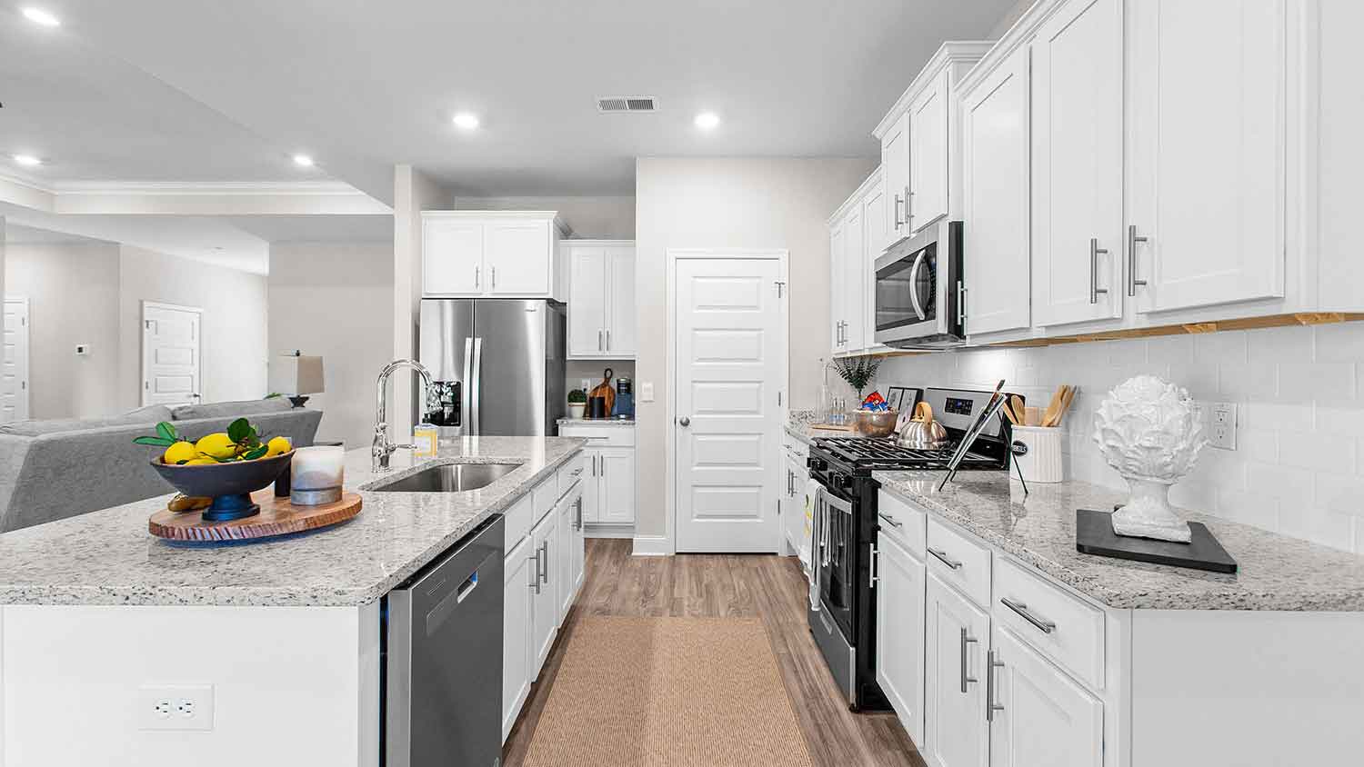 modern kitchen featuring a large island, white cabinetry, and stainless-steel appliances