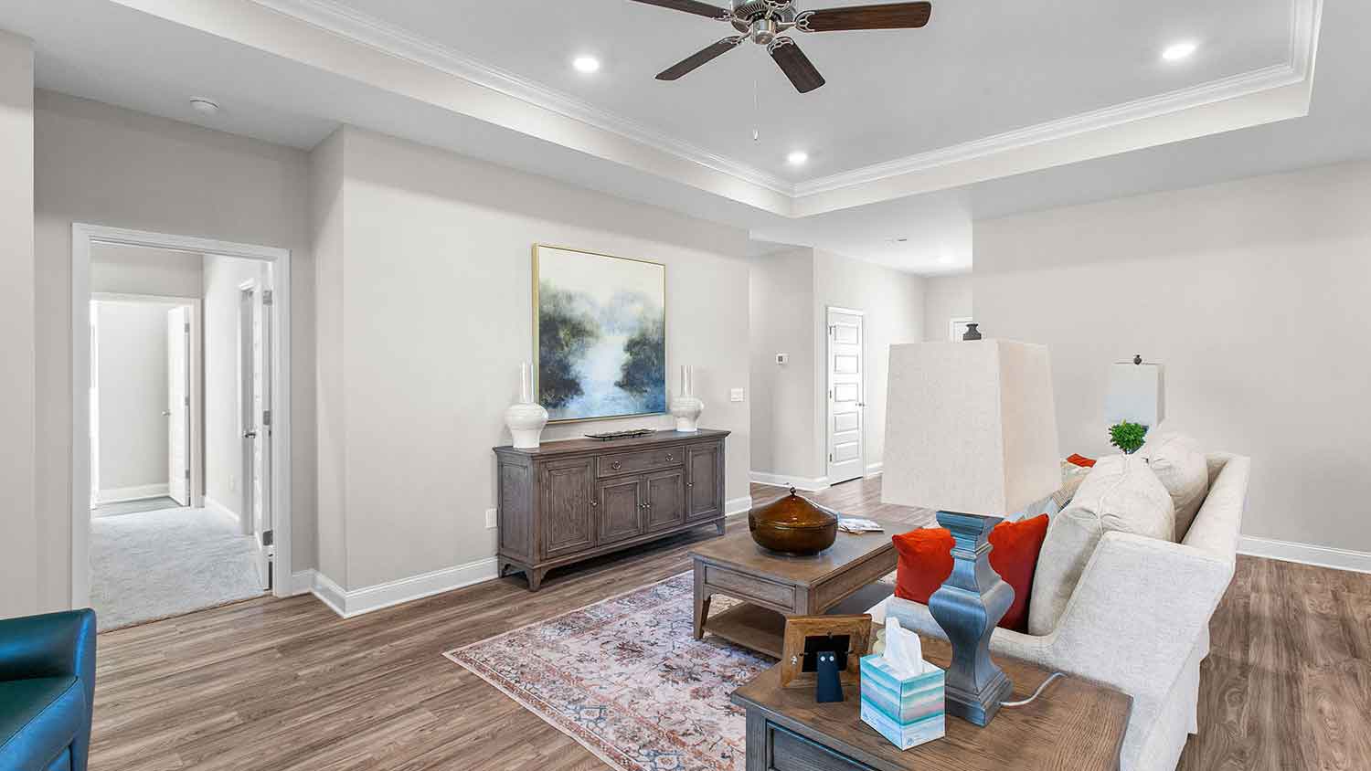 spacious living room featuring a beige sofa, and teal accent chairs
