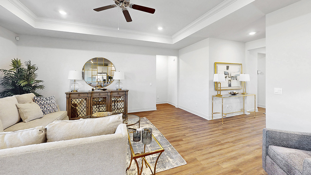living space with hardwood floors, tray ceilings, and ceiling fan