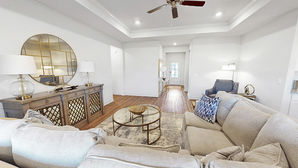 open floor plan living space with hardwood floors, tray ceilings, and ceiling fan