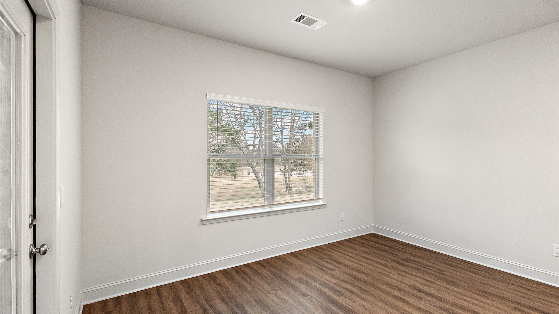 Breakfast nook area adjacent to the kitchen with hardwood flooring and windows for natural light.