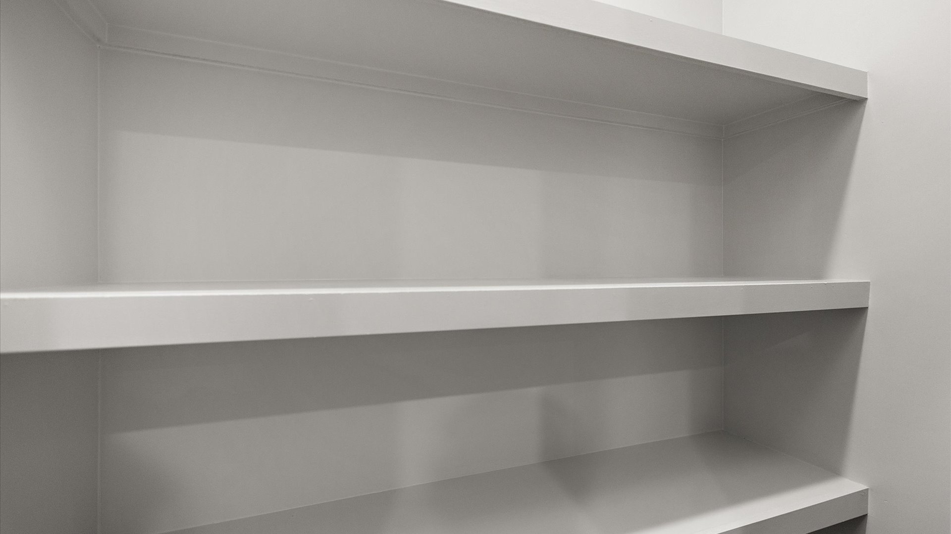 Spacious pantry with wood shelving for plenty of storage.