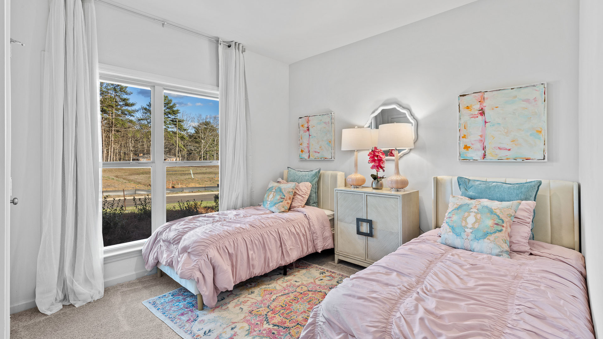 Bedroom featuring 2 twin beds with pink bedding, a large window and blue decor