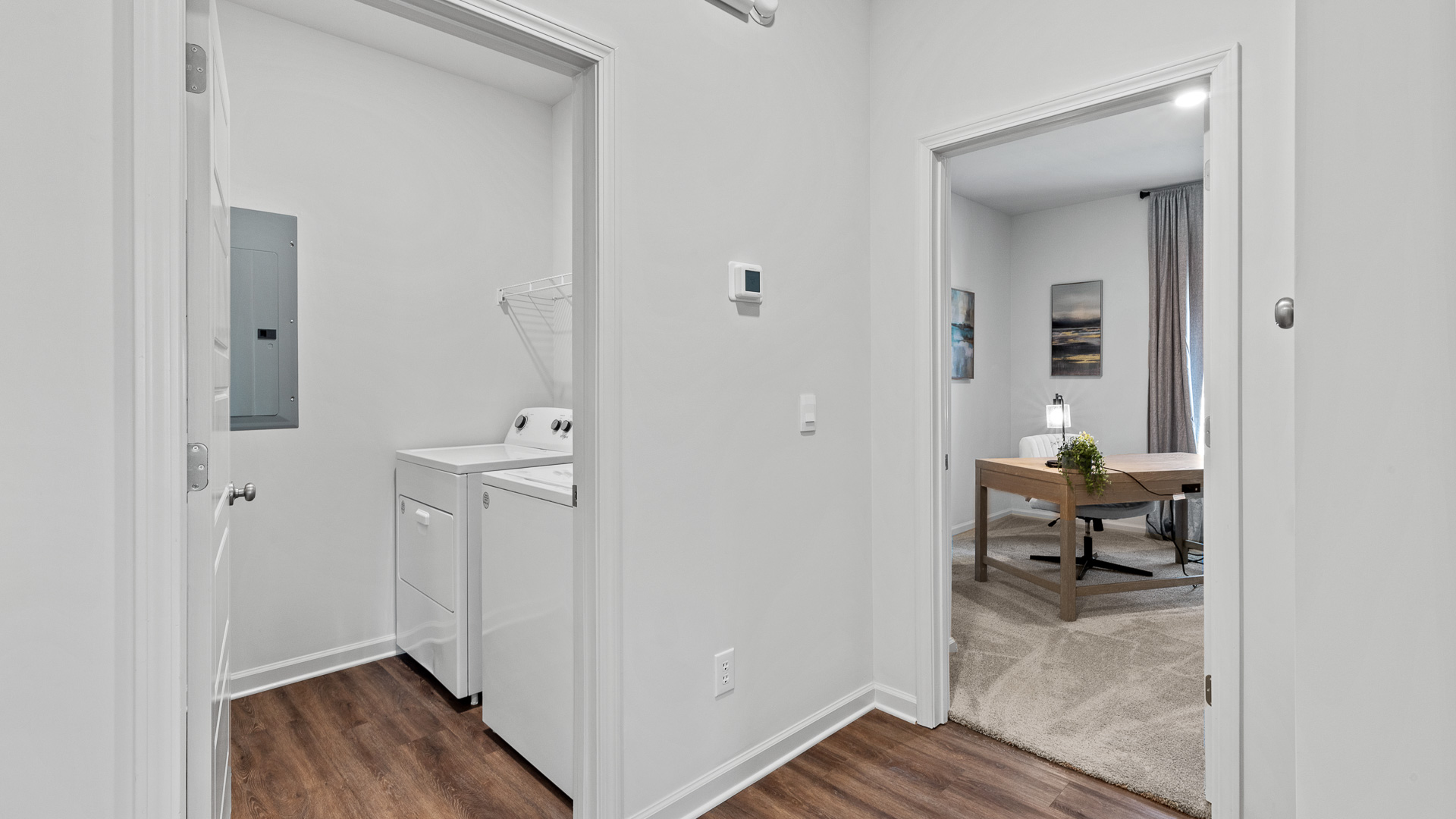 hallway view of the laundry room and office room to the right