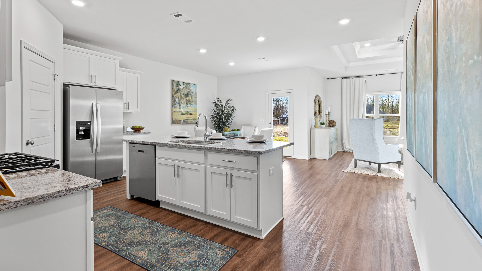 spacious kitchen featuring white cabinetry, large island, and stainless steel appliances