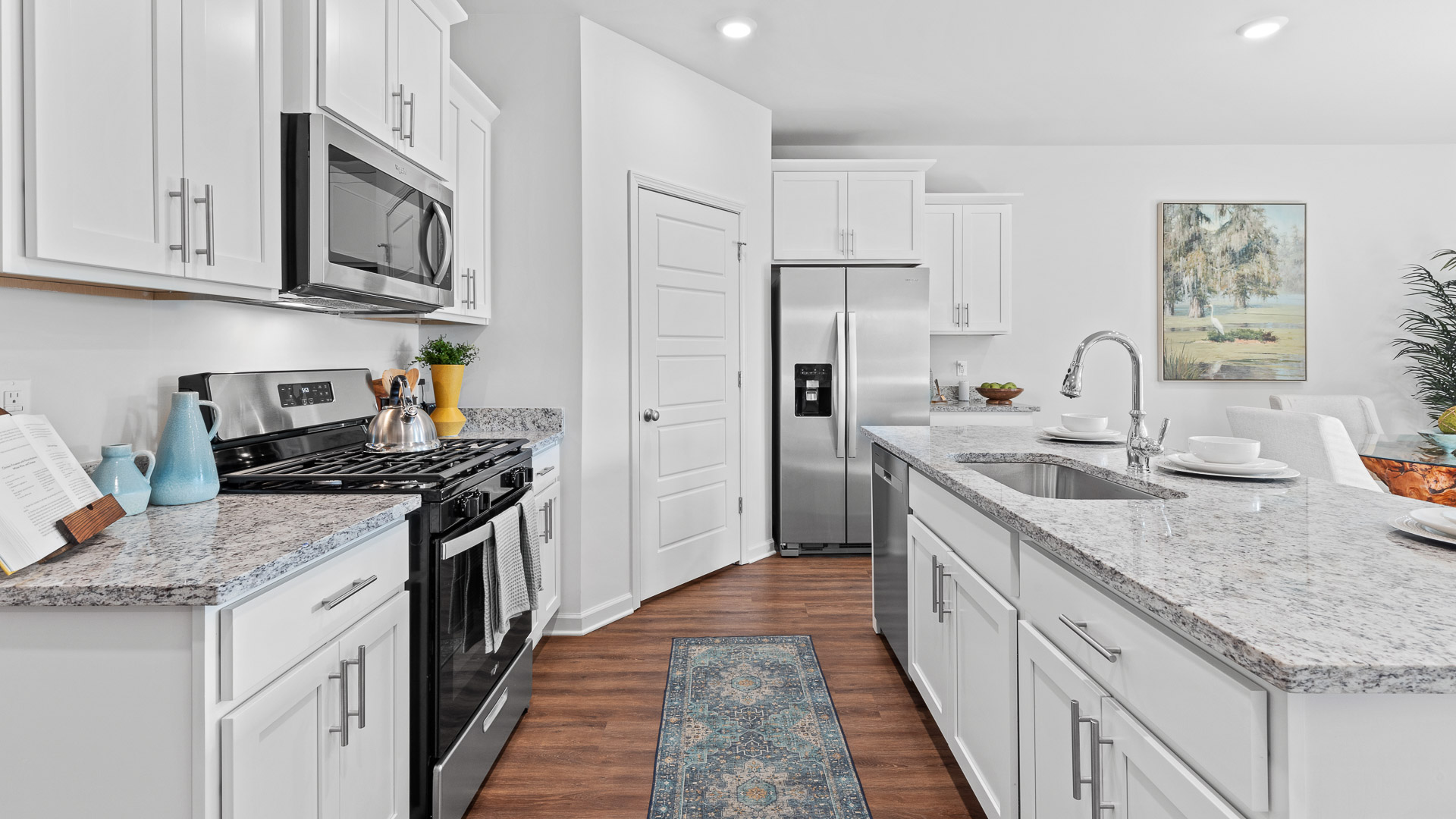spacious kitchen featuring white cabinetry, large island, and stainless steel appliances
