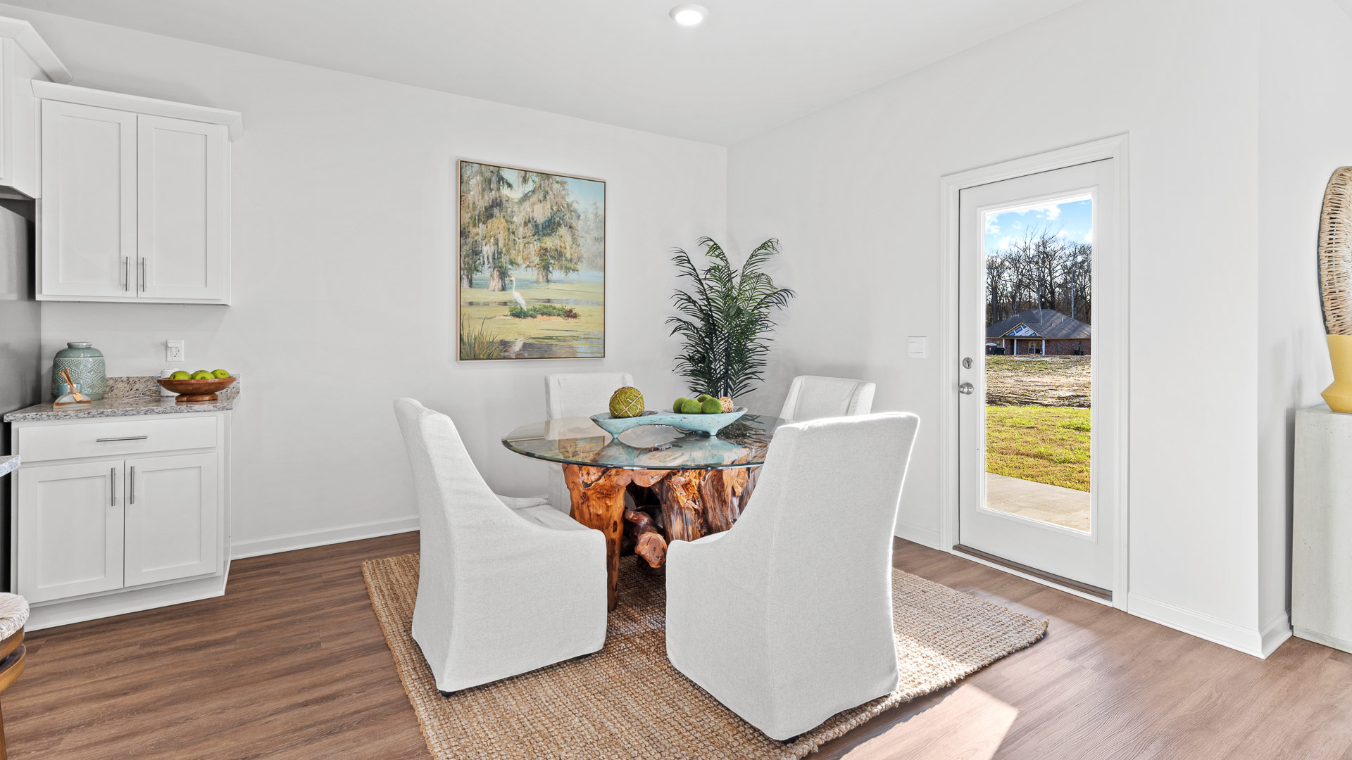 dining area just off the kitchen featuring a wooden glass table with 4 chairs surrounding it