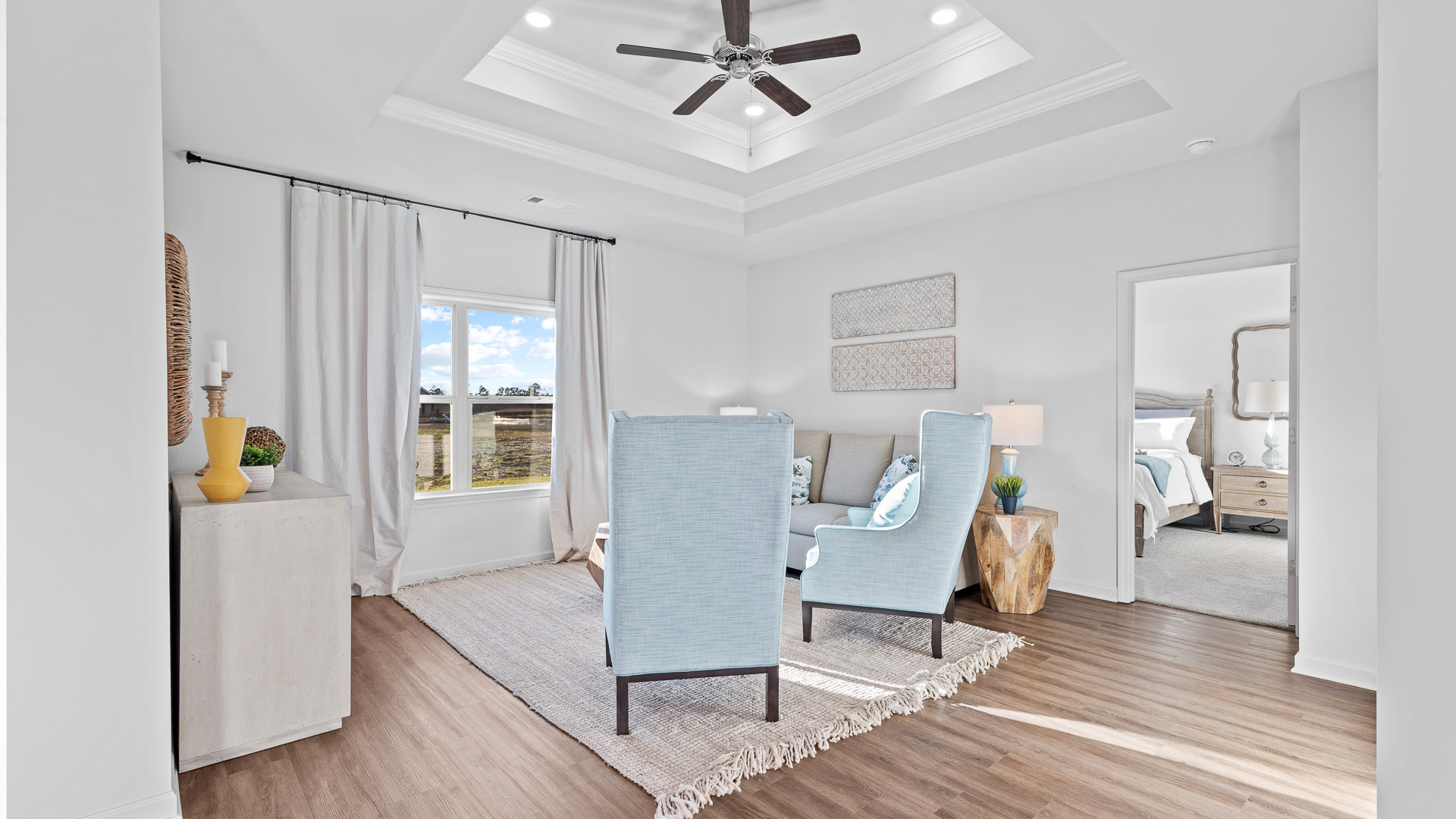 living room featuring a light grey sofa and 2 light blue accent chairs