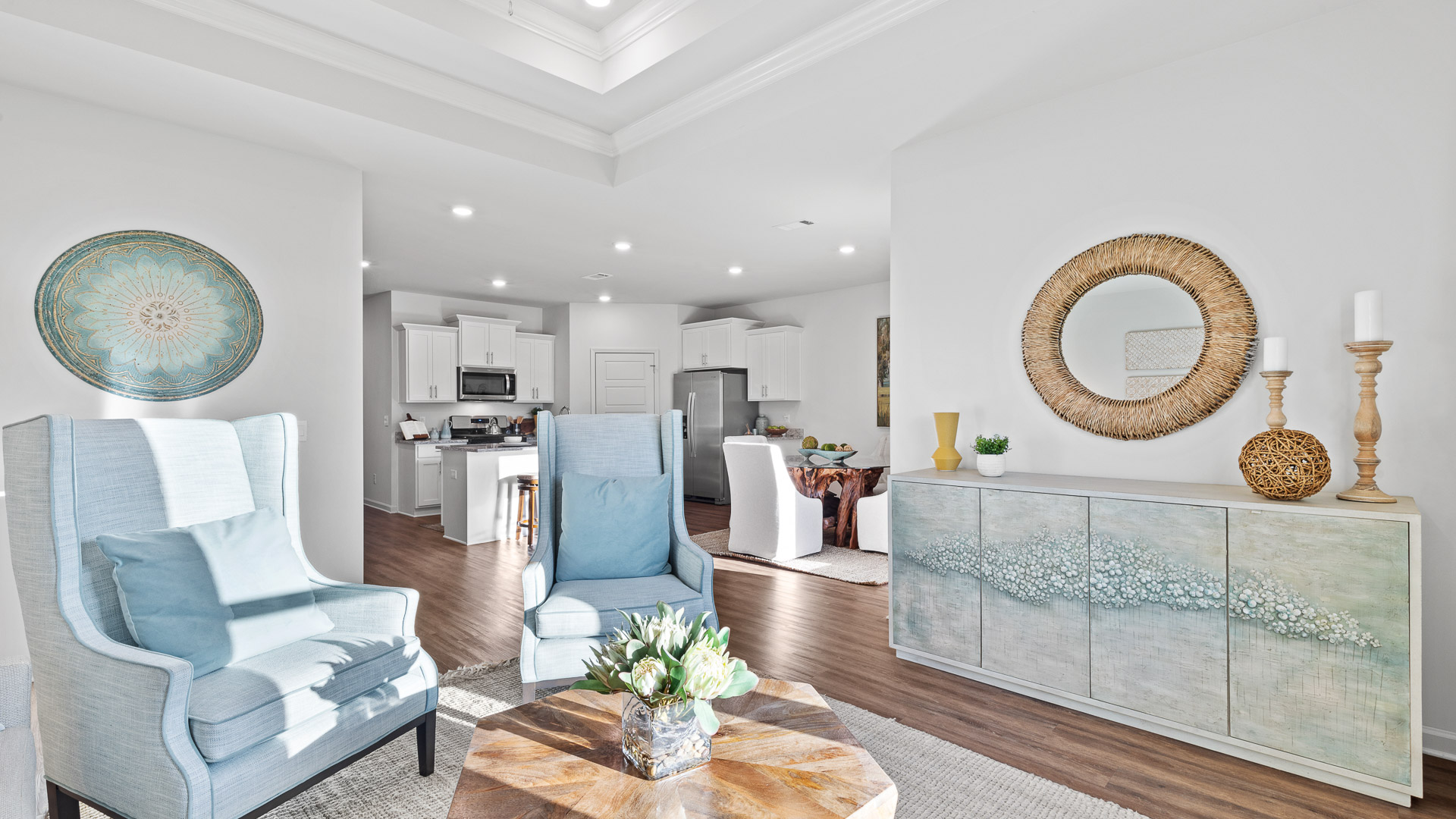 living room featuring a light grey sofa and 2 light blue accent chairs