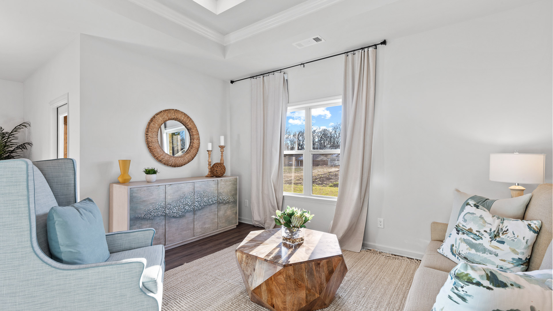 living room featuring a light grey sofa and 2 light blue accent chairs