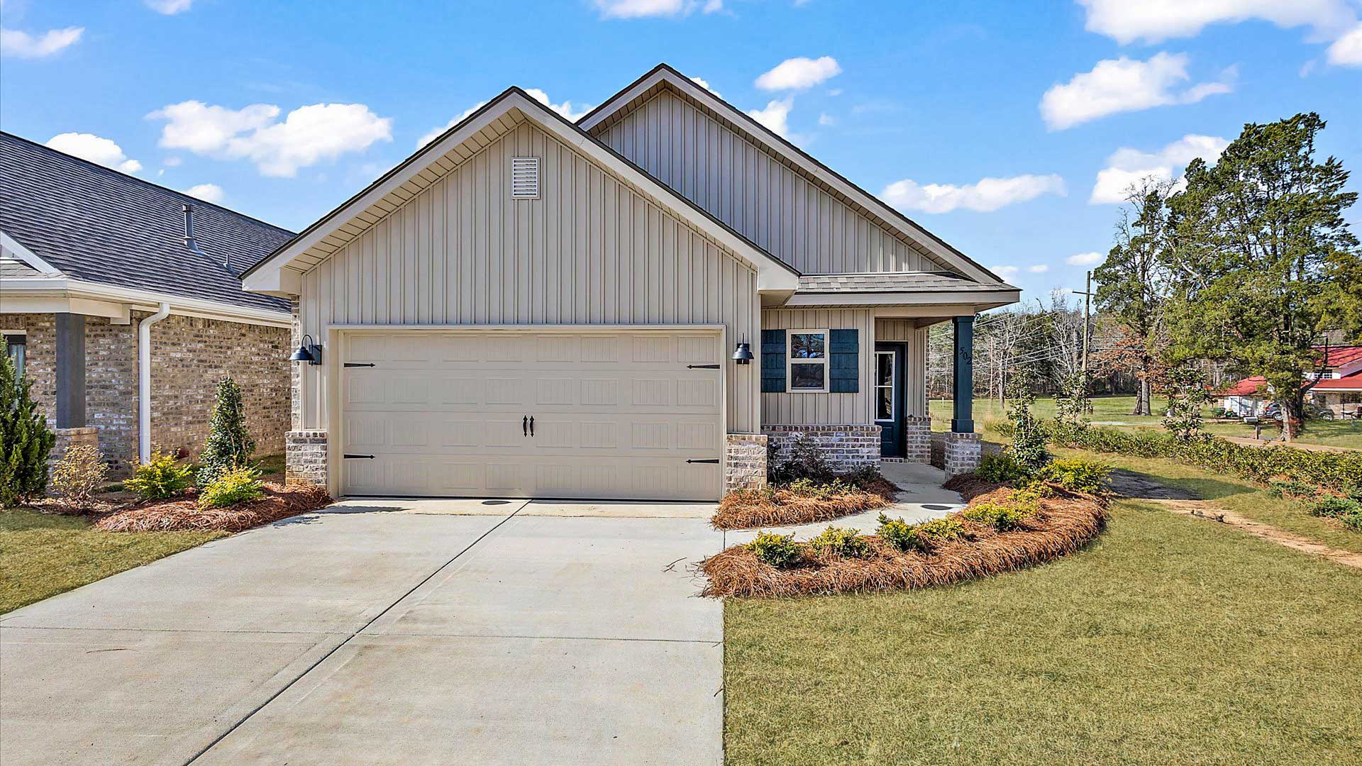 Allex one-story exterior home front view with brown brick, a window, and a two-car garage.