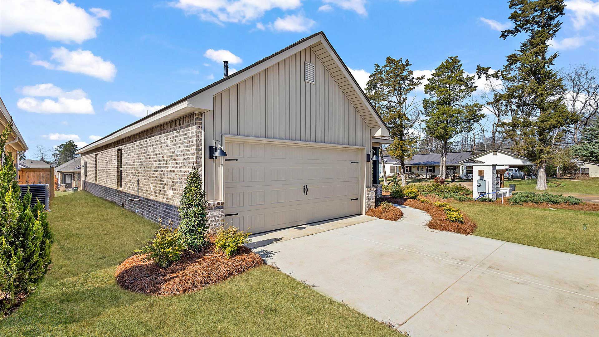 Allex one-story exterior home front view with brown brick, a window, and a two-car garage.