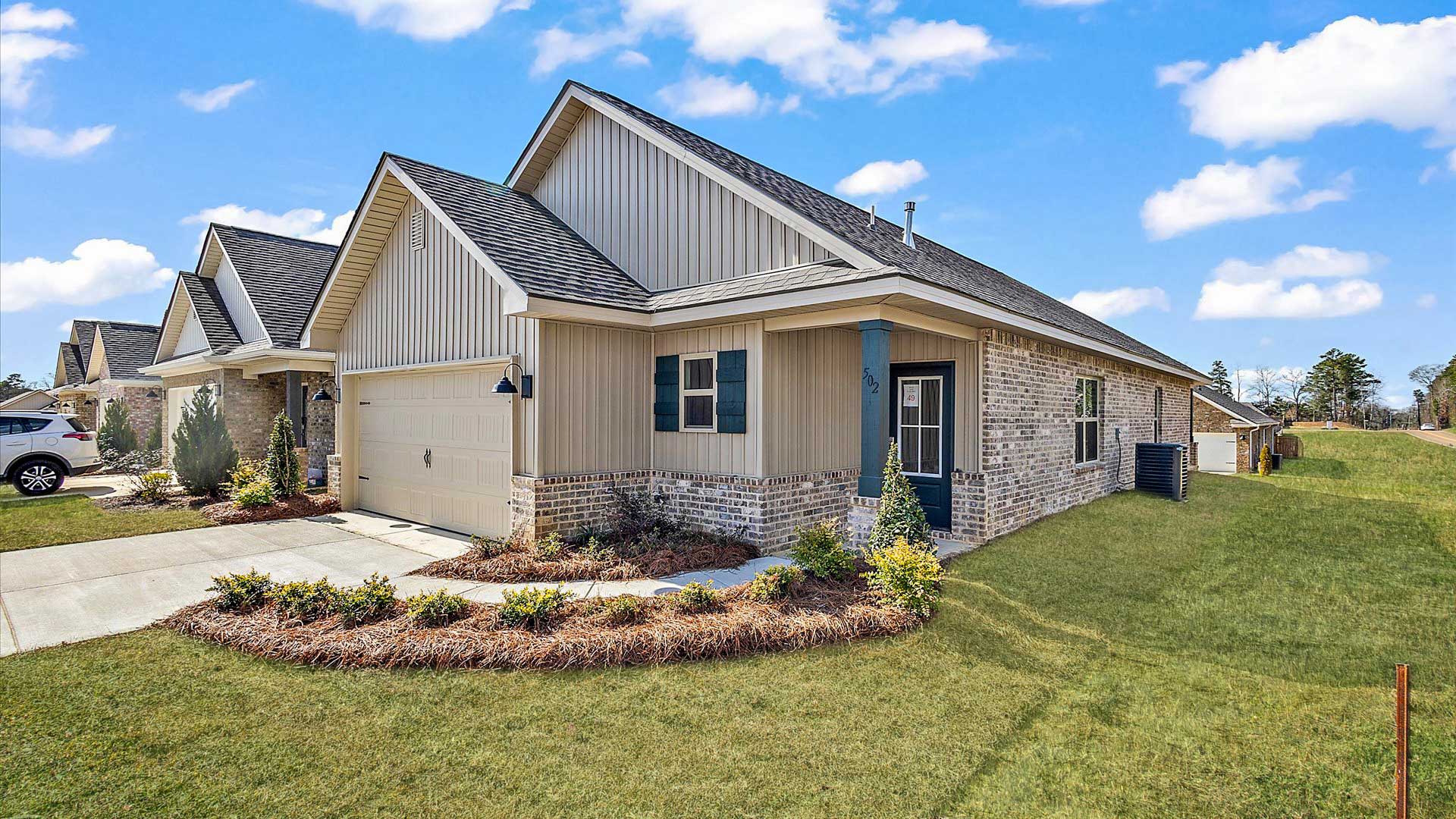 Allex one-story exterior home front view with brown brick, a window, and a two-car garage.