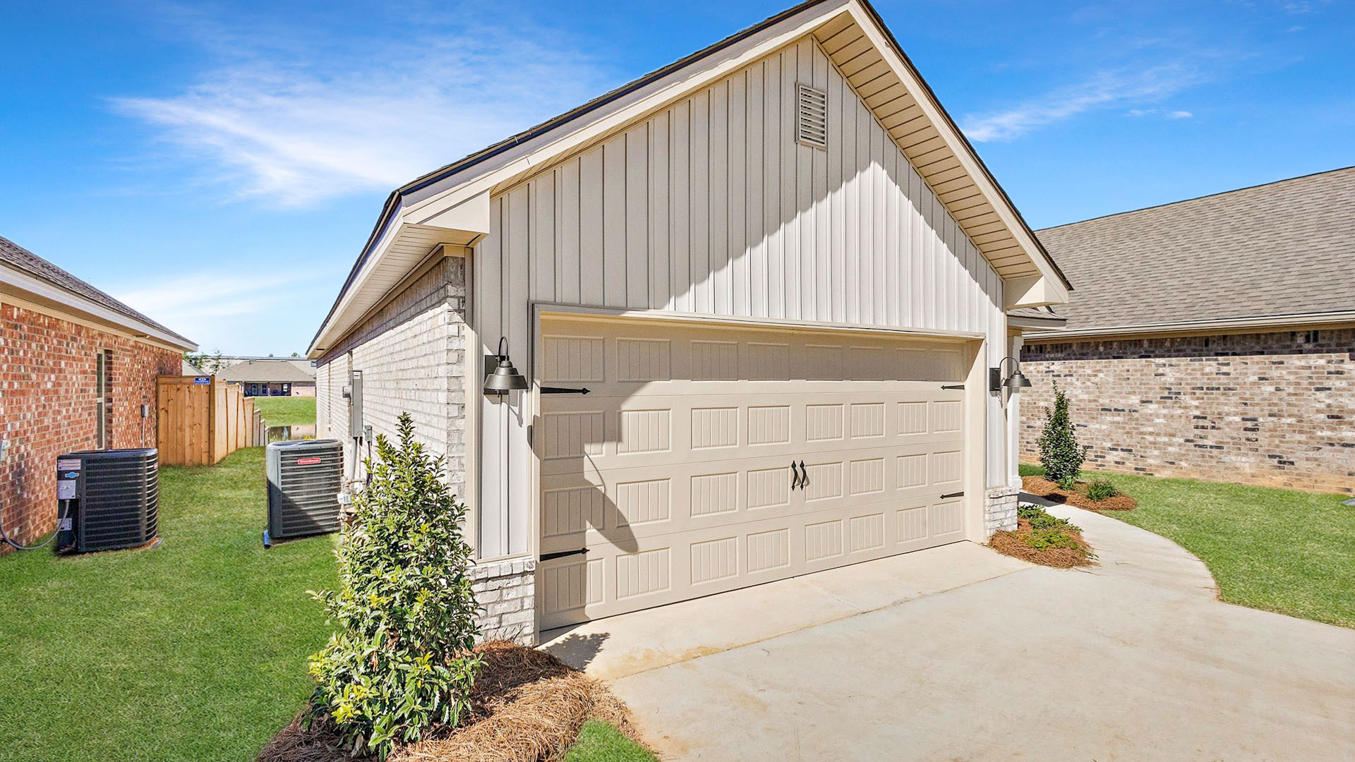 Allex one-story exterior home front view with brown brick, a window, and a two-car garage.