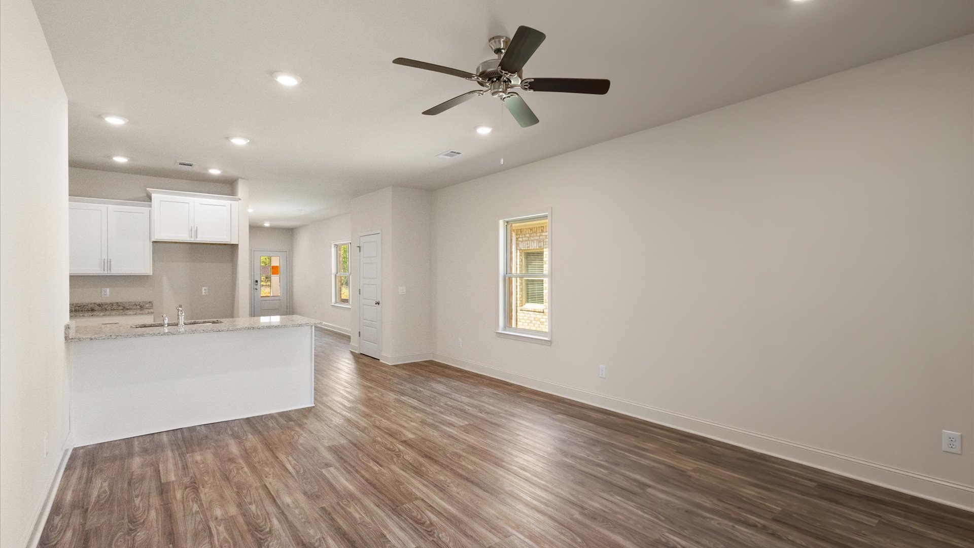 Living area adjacent to a bedroom with a back yard door.