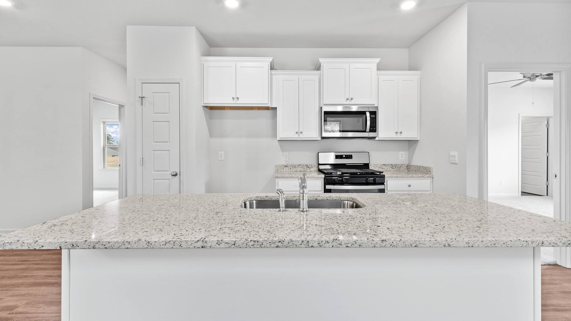 modern kitchen featuring white cabinetry, large island and stainless steel appliances