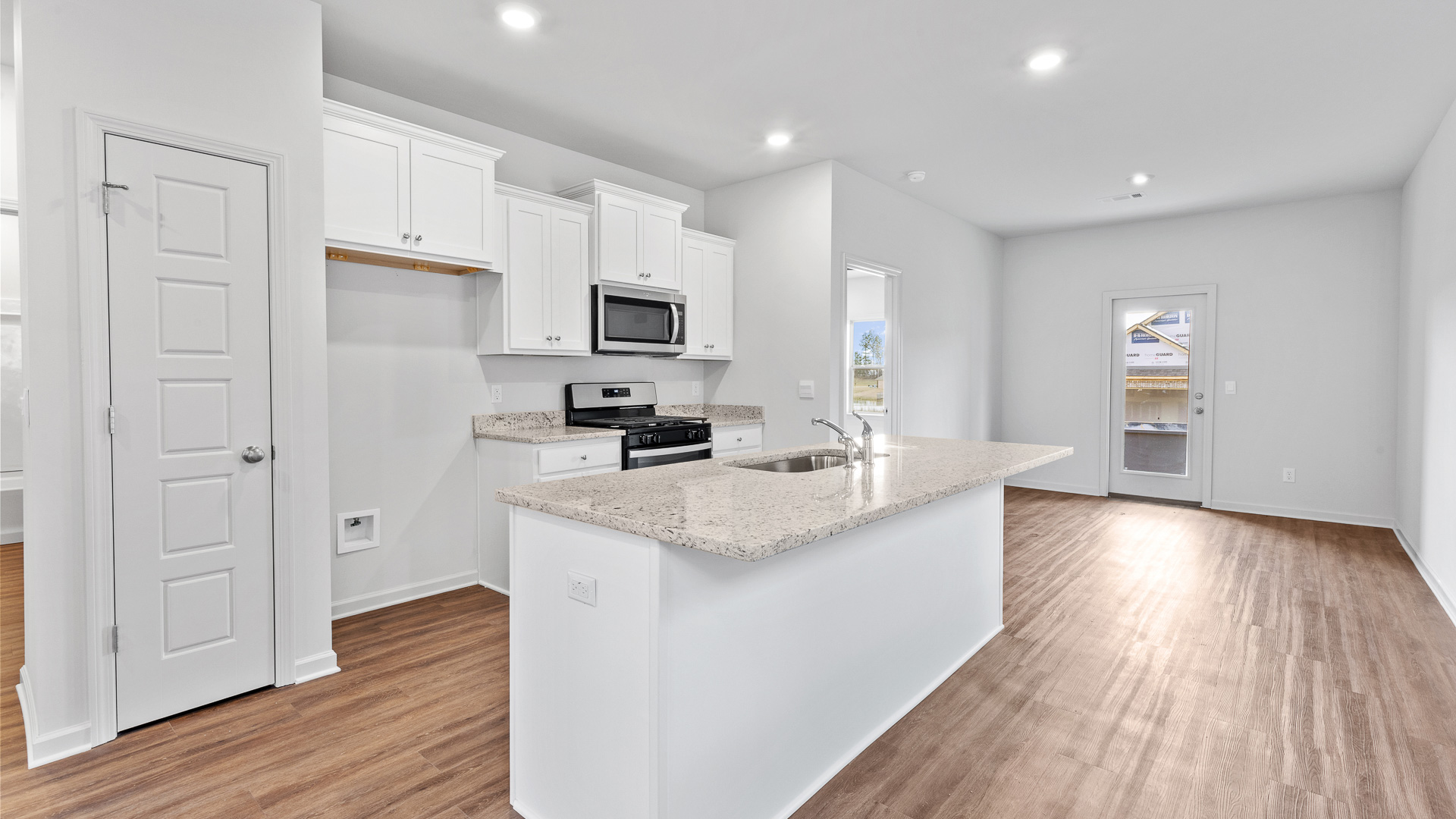 modern kitchen featuring white cabinetry, large island and stainless steel appliances