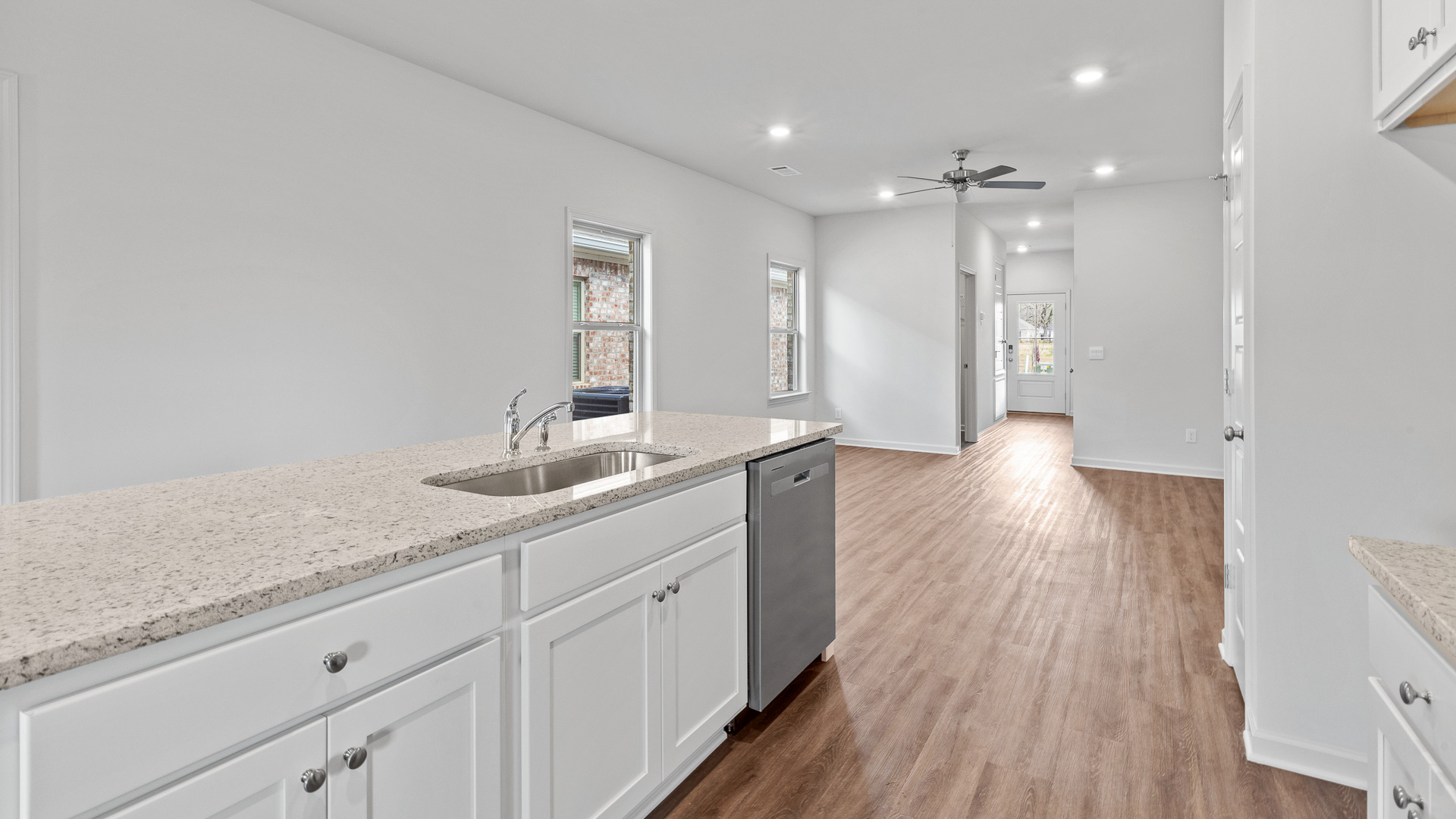 modern kitchen featuring white cabinetry, large island and stainless steel appliances