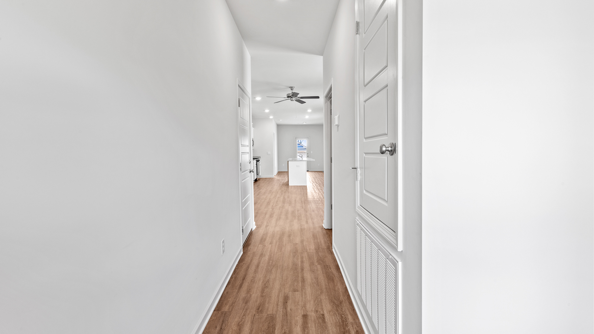 entry hallway featuring brown floors, and white walls