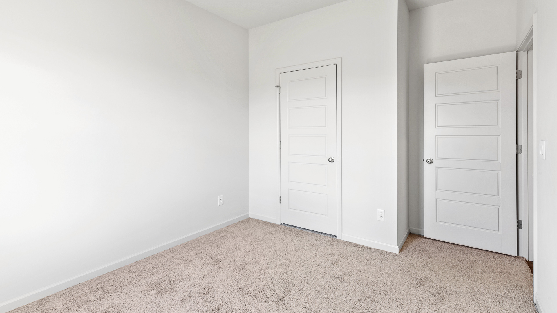 bedroom featuring beige carpet, white walls and a closet